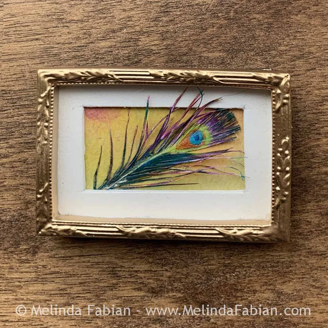 3D paper sculpture of a peacock feather in a tiny frame