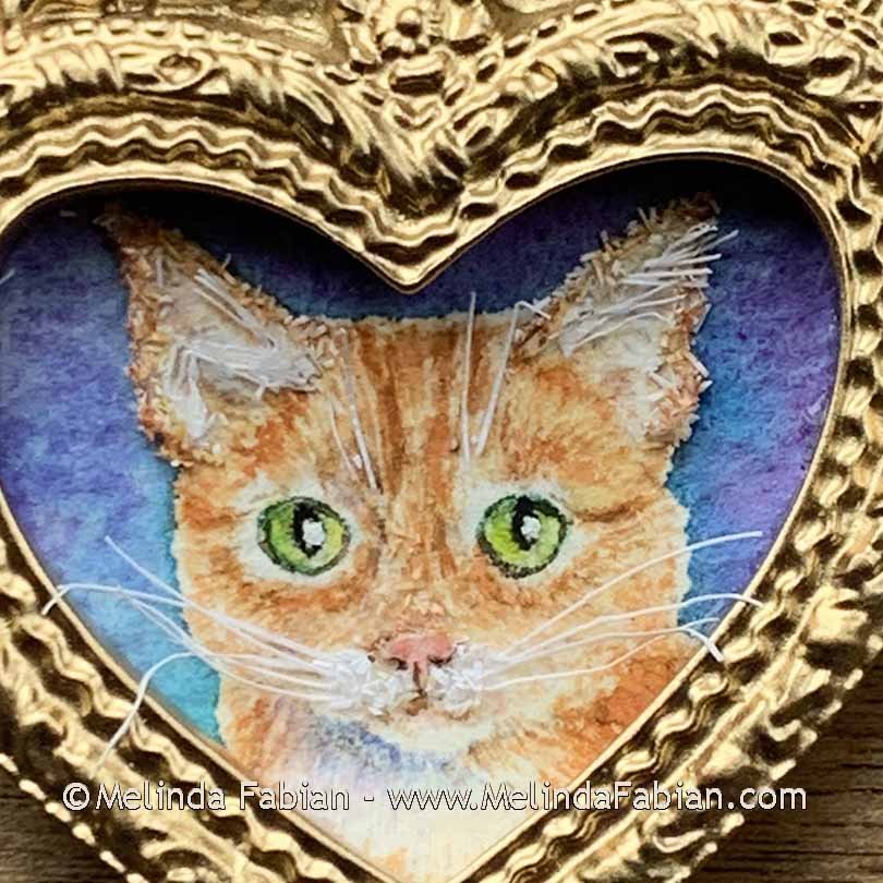 paper cat painting in a heart shaped frame