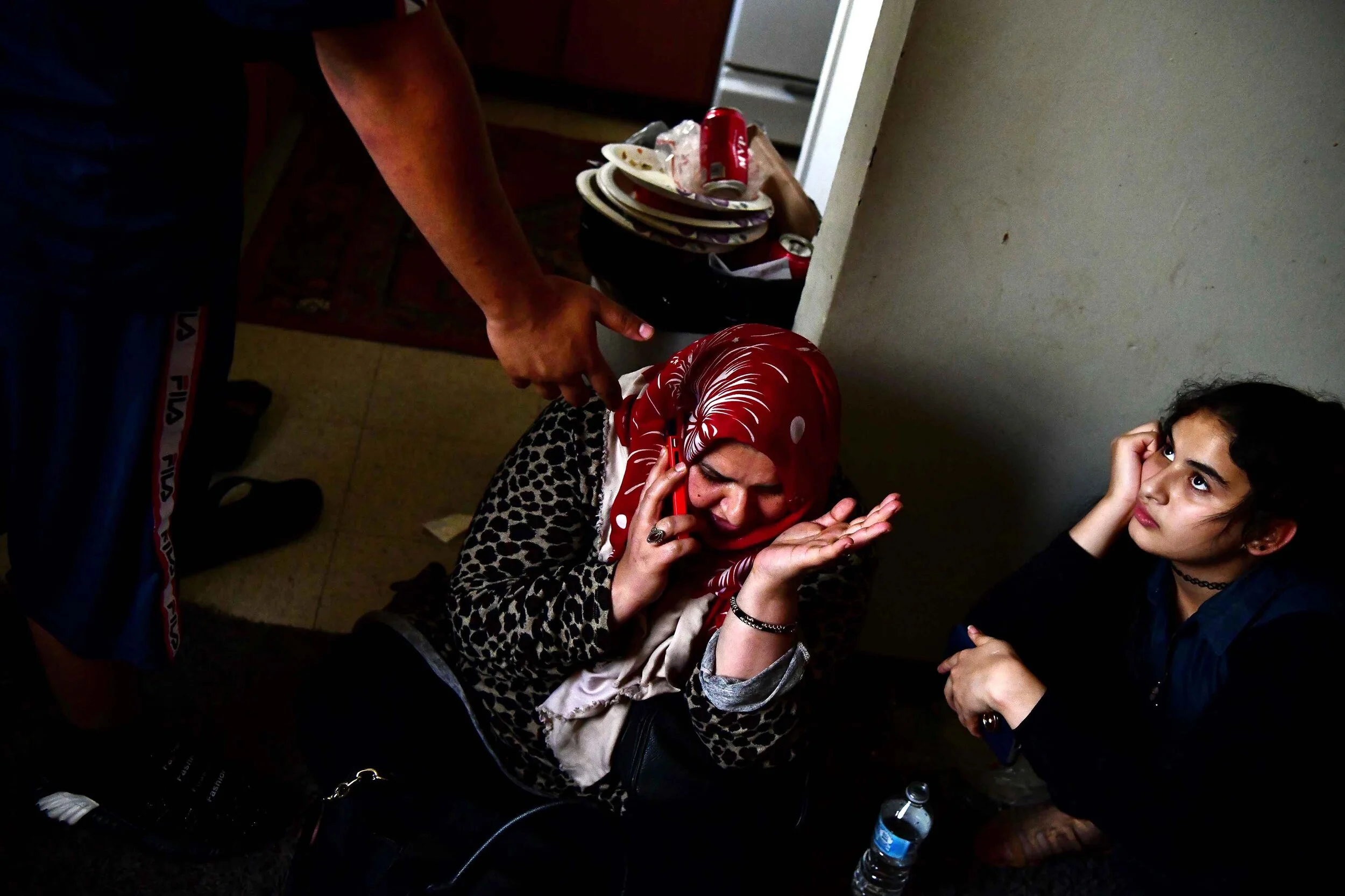  Zaynab Al Hraishawi speaks to her husband, Mohammed who's currently working in Iraq, about a possible eviction from their apartment, while Abbas, left, asks his mom to speak to his father to ask for permission to get money to watch a movie with his 