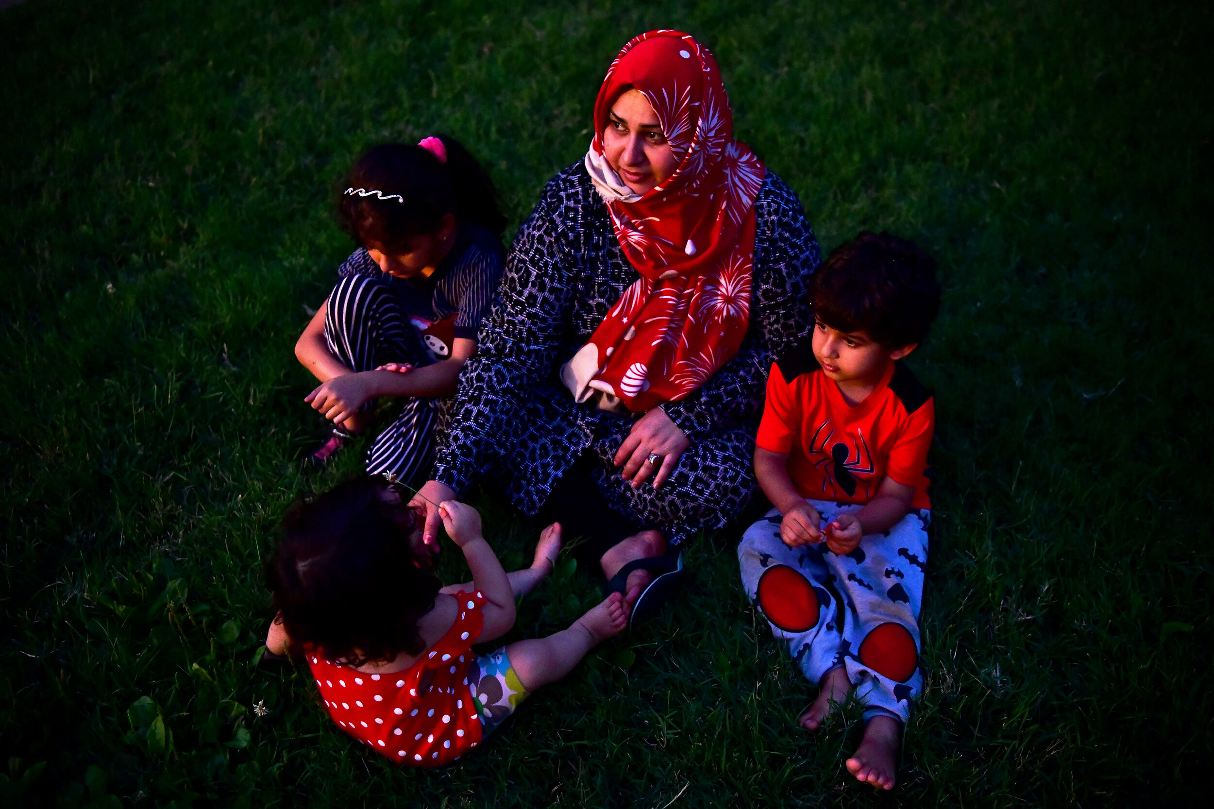  Zaynab Al Hraishawi watches the sunset with her daughters, Fatime, 8, left, Zahra, 1, bottom, and son, Baqer, 4, right, on Friday, August 9, 2019, outside their home in Columbia, Missouri. The family came to the United States on December 14, 2017, a