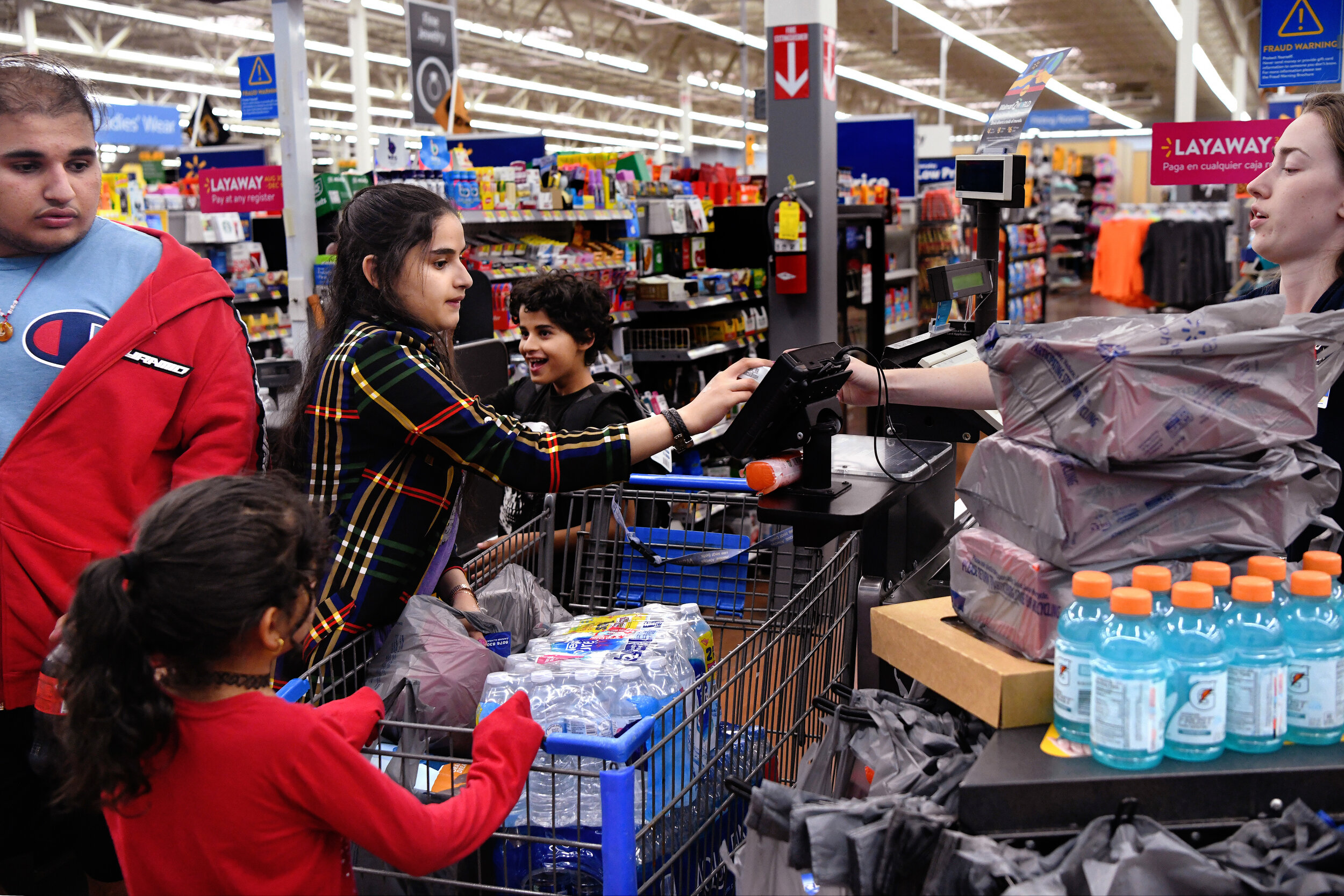  Narjes, 14, center, pays for the families groceries with money she got from her mother. Their mother doesn’t speak English on a level high enough to get groceries on her own so she often relies on her oldest children to do everyday tasks that involv