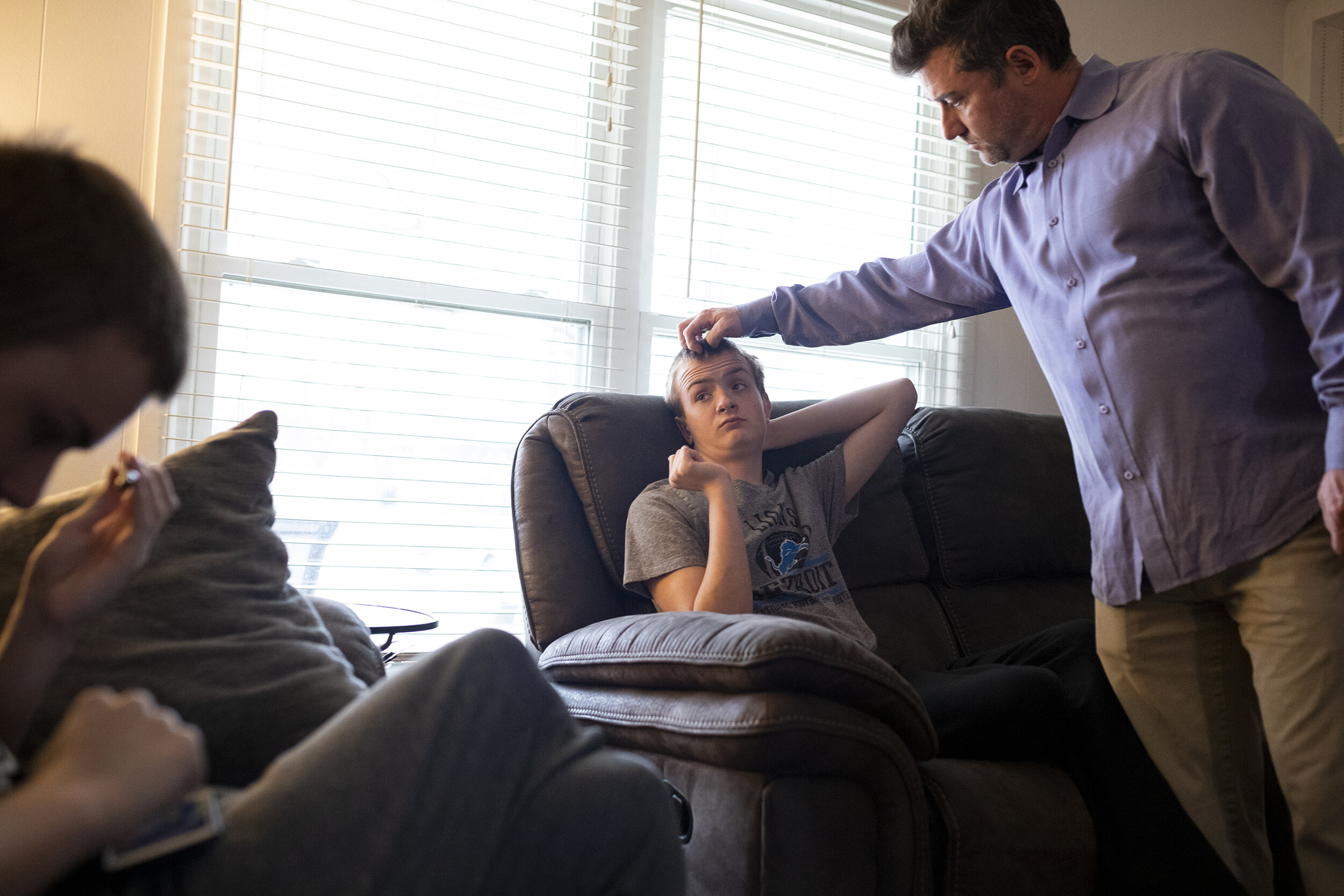  Bob Carleton scratches Jackson's head as Connor, left, reads on Wednesday, March 10, 2021, in Troy. Bob is a history teacher at Ernest W. Seaholm High School where his three son's regularly attend in person school, but due to the COVID-19 pandemic, 