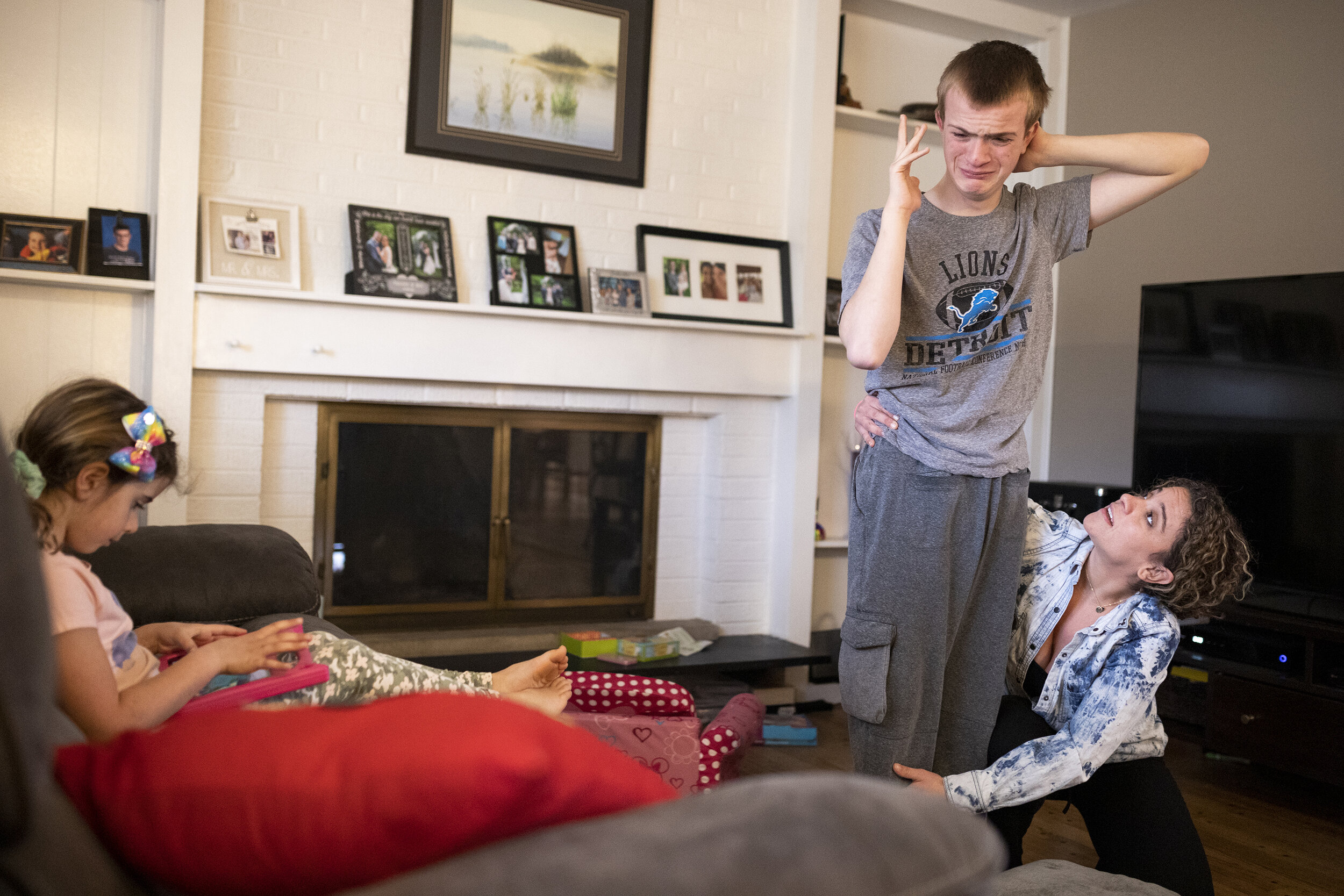  Danielle Vernon-Carleton helps her step-son Jackson, 16, balance on a pillow during his online physical therapy exercises while her daughter Bella, 6, plays on a tablet on Wednesday, March 10, 2021, in Troy. Danielle had to resign from her job as a 