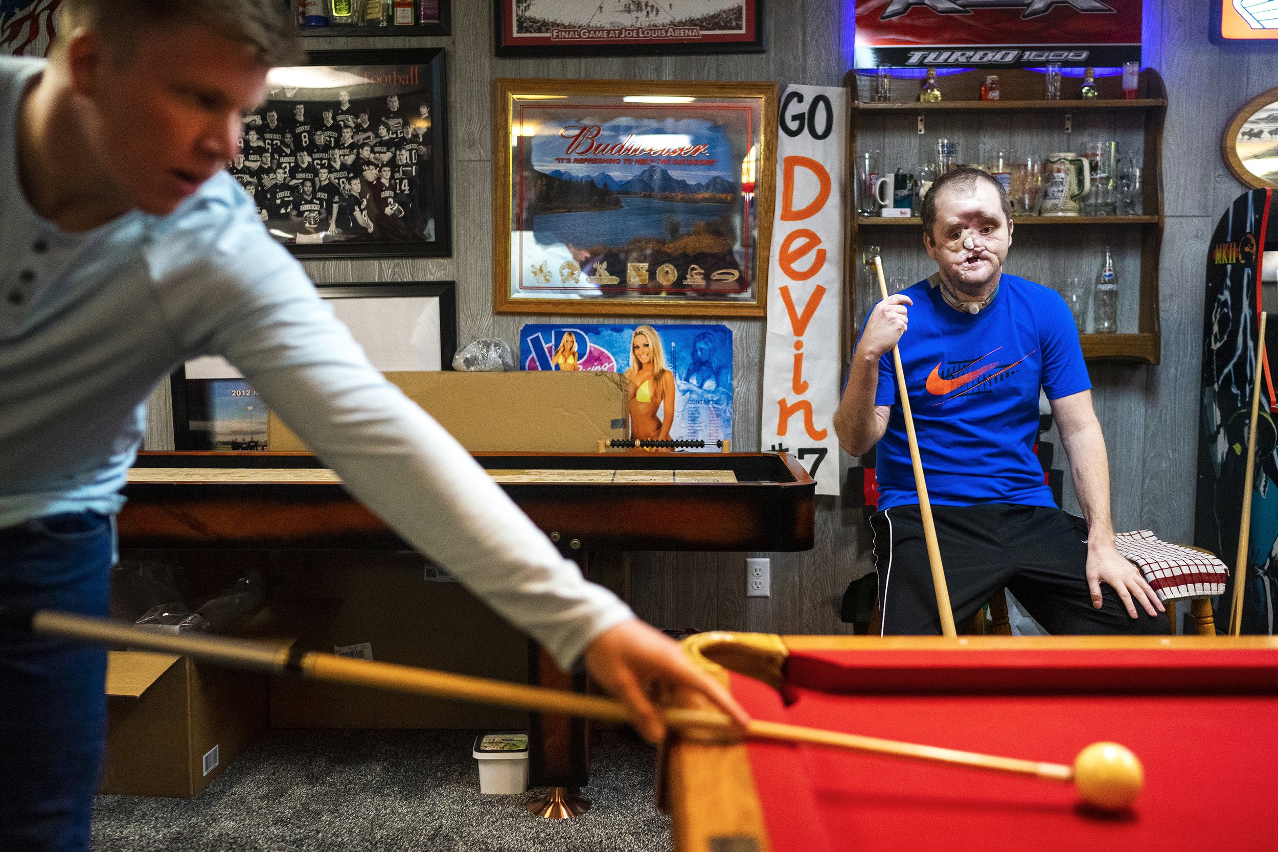  Devin, left, cues up a shot as Derek Pfaff, right, watches at their basement decorated with high school football memorabilia from each one the families four brothers on Sunday, April 25, 2021, in Harbor Beach. Derek attempted suicide at the age of 1