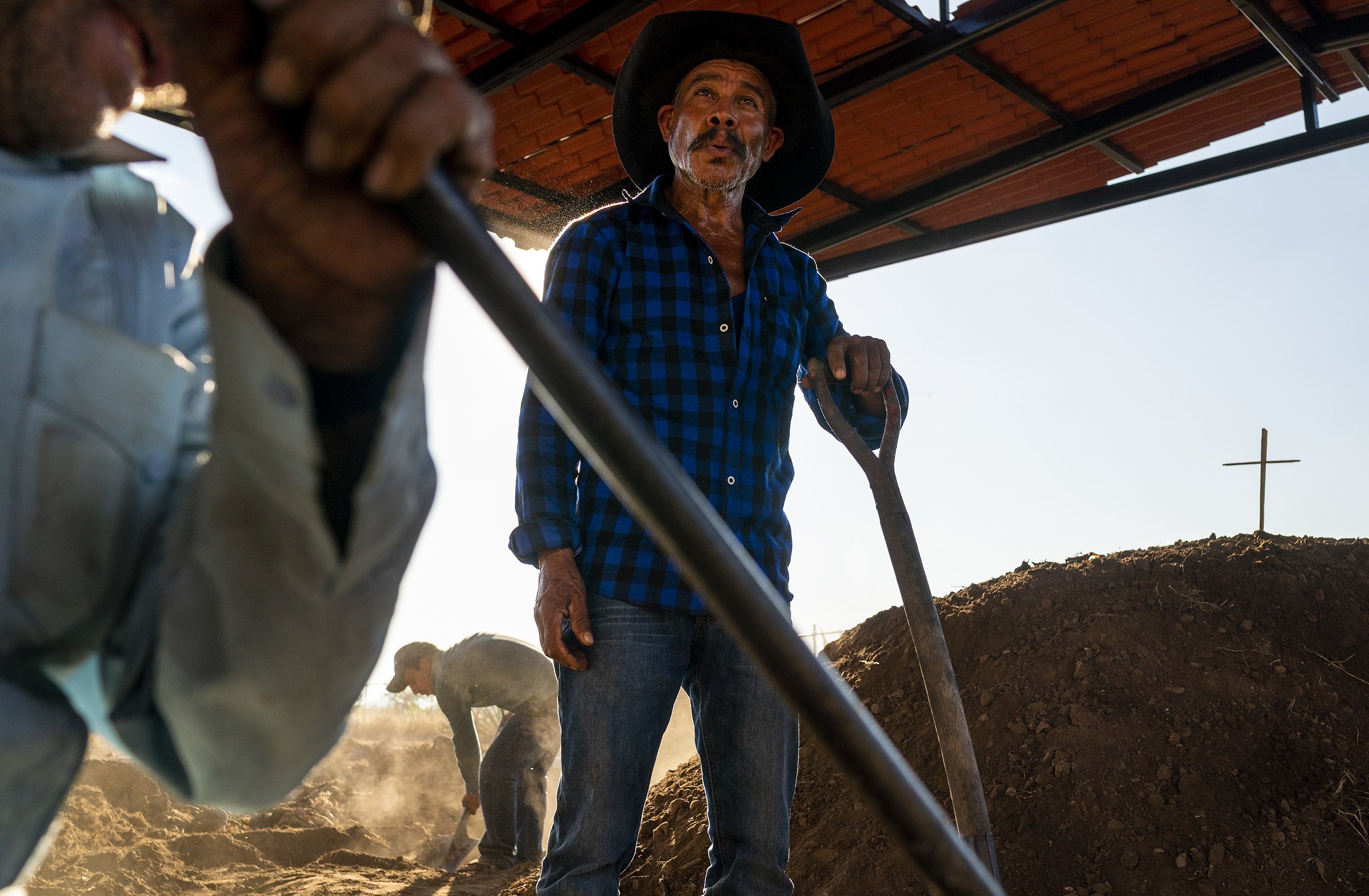  Epifanio Vásquez Ríos, center, takes a break from shoveling dirts on top of the oven at Hacienda Carreño on Sunday, Dec. 6, 2021 in San Dionisio Ocotlán, Oaxaca, Mexico. The oven is topped with a cross as an offering to the gods for a good batch of 