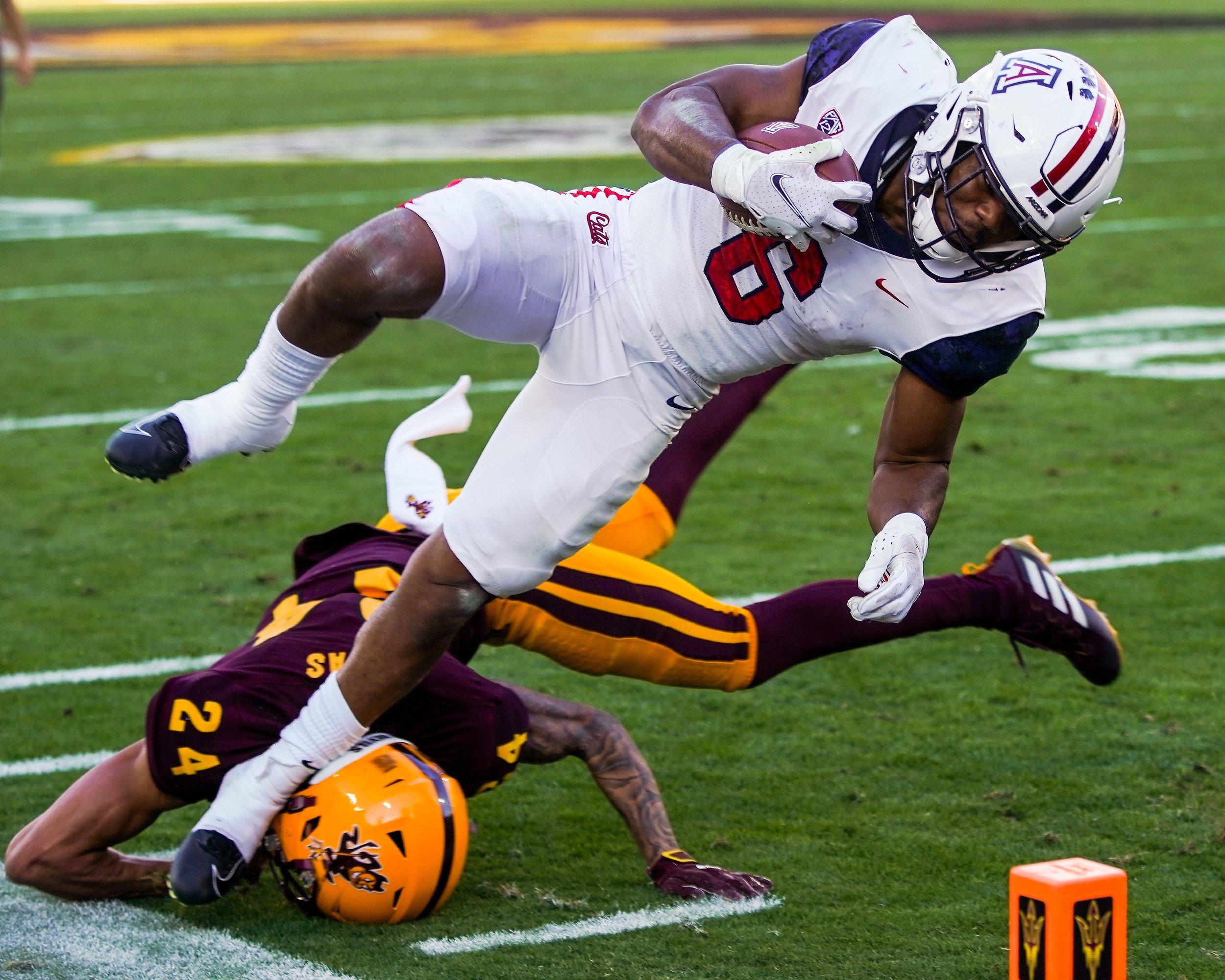  Sun Devils defensive back Chase Lucas (24), left, tackles Wildcats running back Michael Wiley (6), right, to stop a touchdown during the second half against the University of Arizona at Sun Devils Stadium on Saturday, Nov. 27, 2021, in Tempe.       