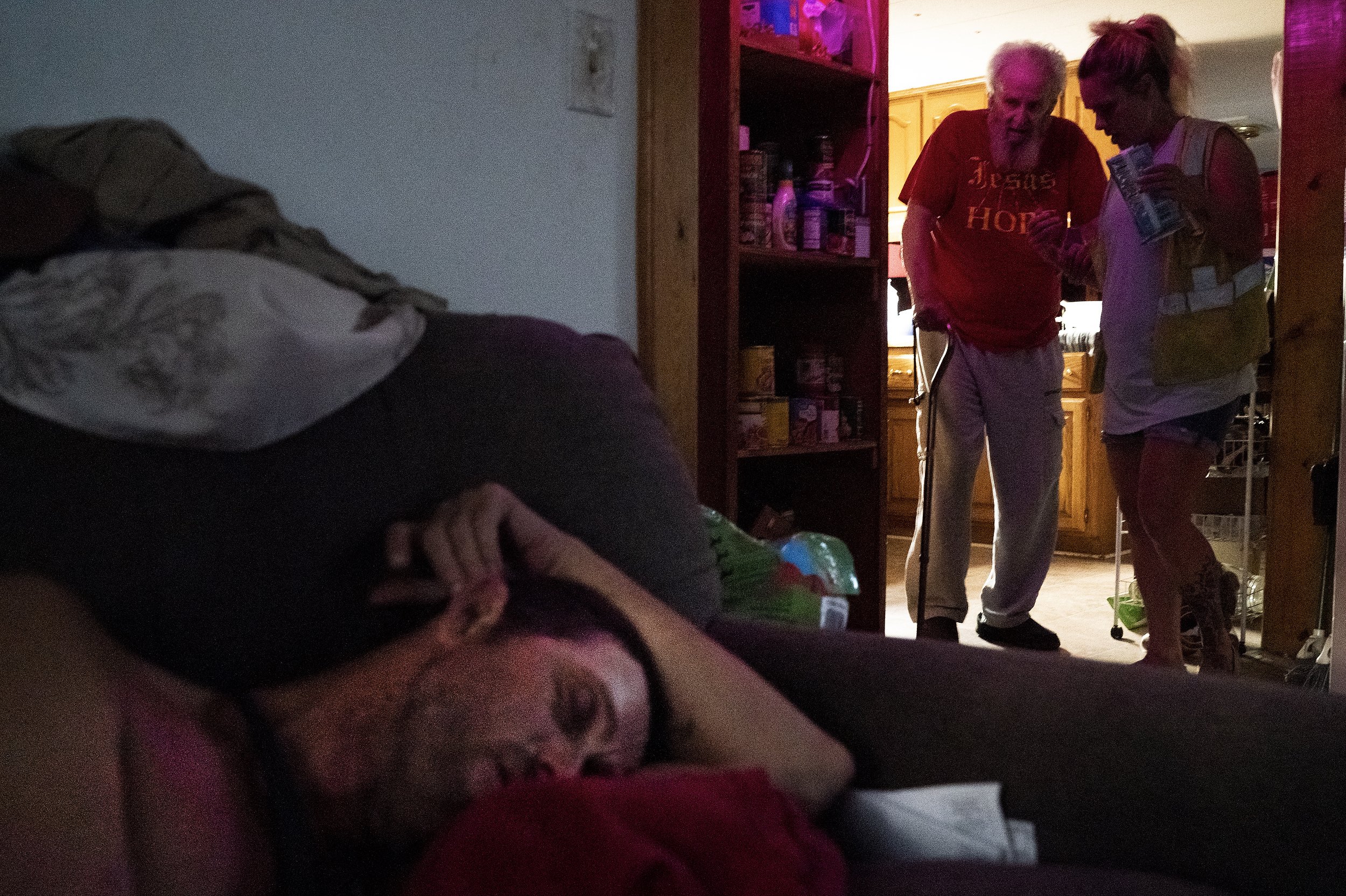  Elizabeth Singleton, right, assists her grandfather Daryel Miller, 80, after Daryel Franklin Miller, 50, at left, passed out on the couch following a long day of drinking on Wednesday, September 21, 2022, in Excelsior Springs, Mo. "What's sad is tha