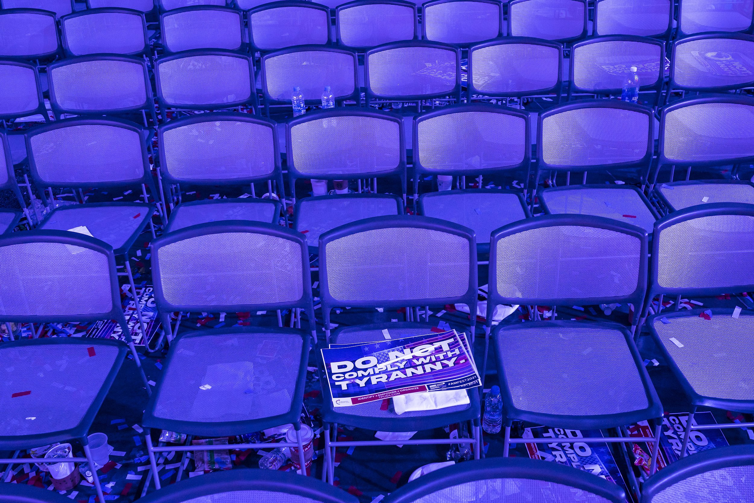  A sign reading "Do Not Comply With Tyranny" is left on a chair after attendees depart following the closing speaker during the second day of AmericaFest 2021 hosted by Turning Point USA on Sunday, Dec. 19, 2021, in Phoenix. The four day convention a