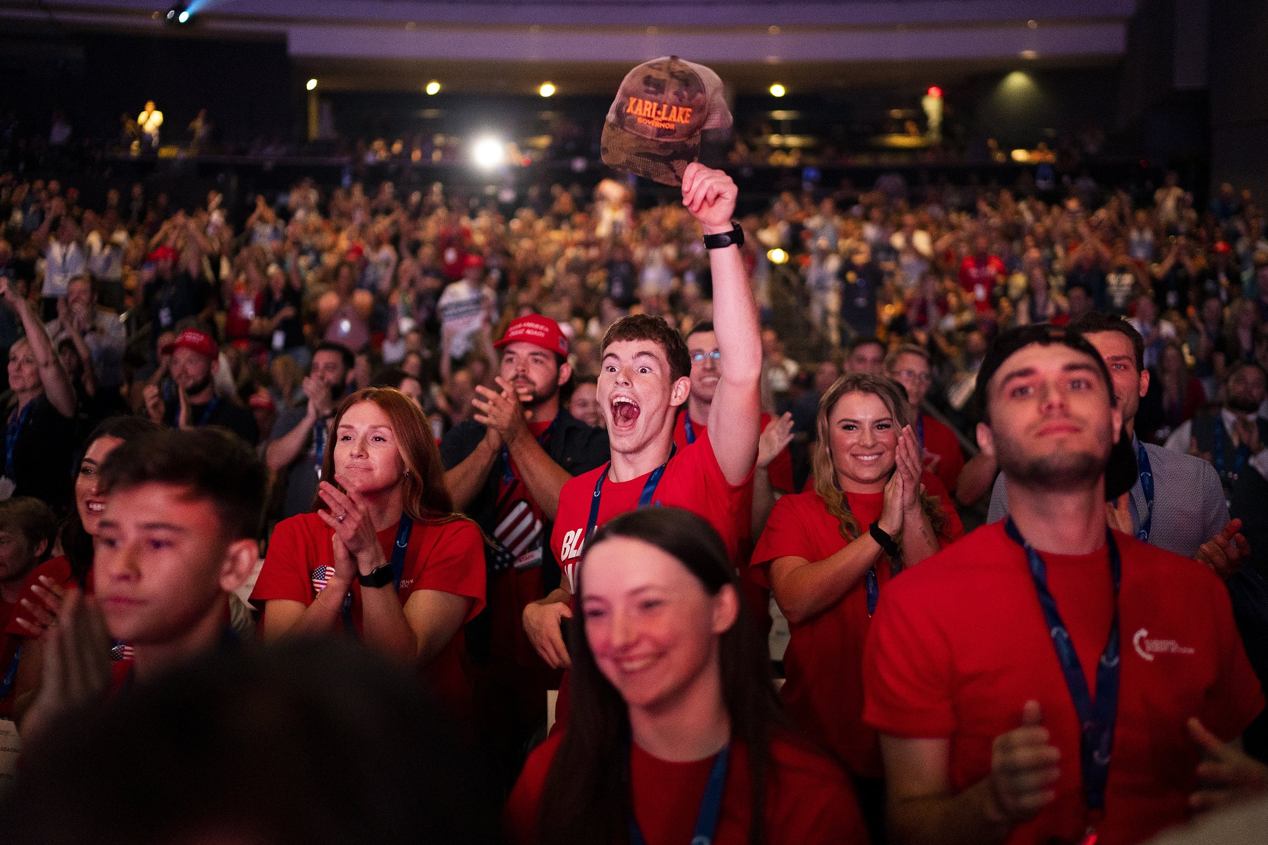  Brandon, who asked to omit his last name, at center, lifts his Kari Lake campaign has as Kari Lake, Republican candidate for Governor of Arizona, speaks during a Unite and Win rally held by Turning Point Action at the Arizona Financial Theater on Su