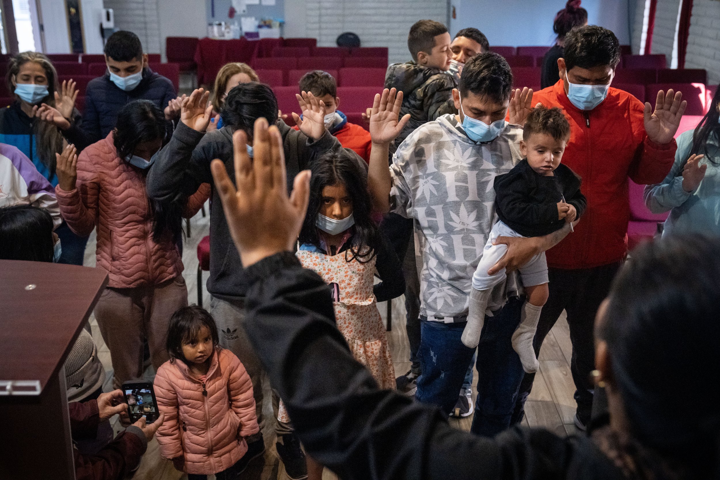  Pastor Hector Ramirez leads a prayer to protect a group of migrants on their journeys after they arrived to Iglesia Cristiana El Buen Pastor on Thursday, Dec. 22, 2022, in Mesa. The group of migrants from various Central and South American countries