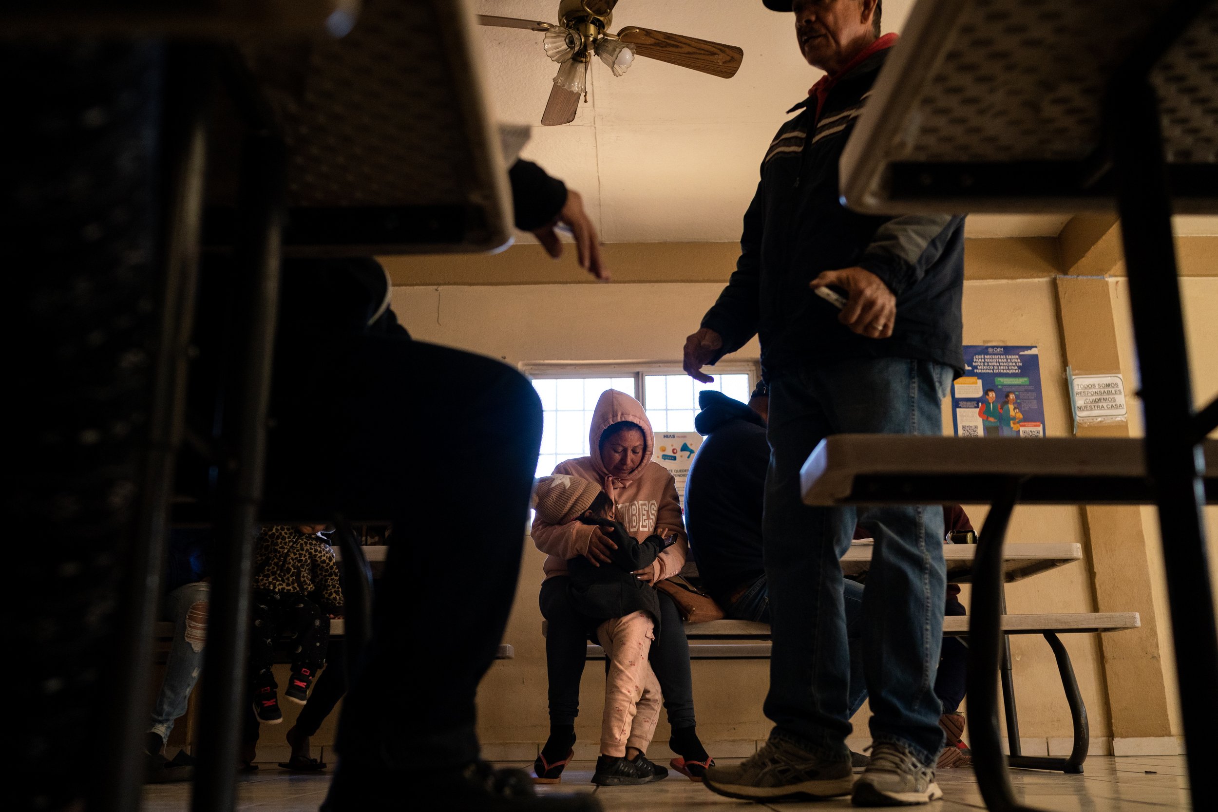  A migrant mother holds her daughter, who’s names has been omitted for safety concerns, as she listens to Jose Manuel Oroszco Perez, at right, teach a class on auto mechanics for a group of adult migrants at La Casa de Misericordia on Friday, Jan. 7,