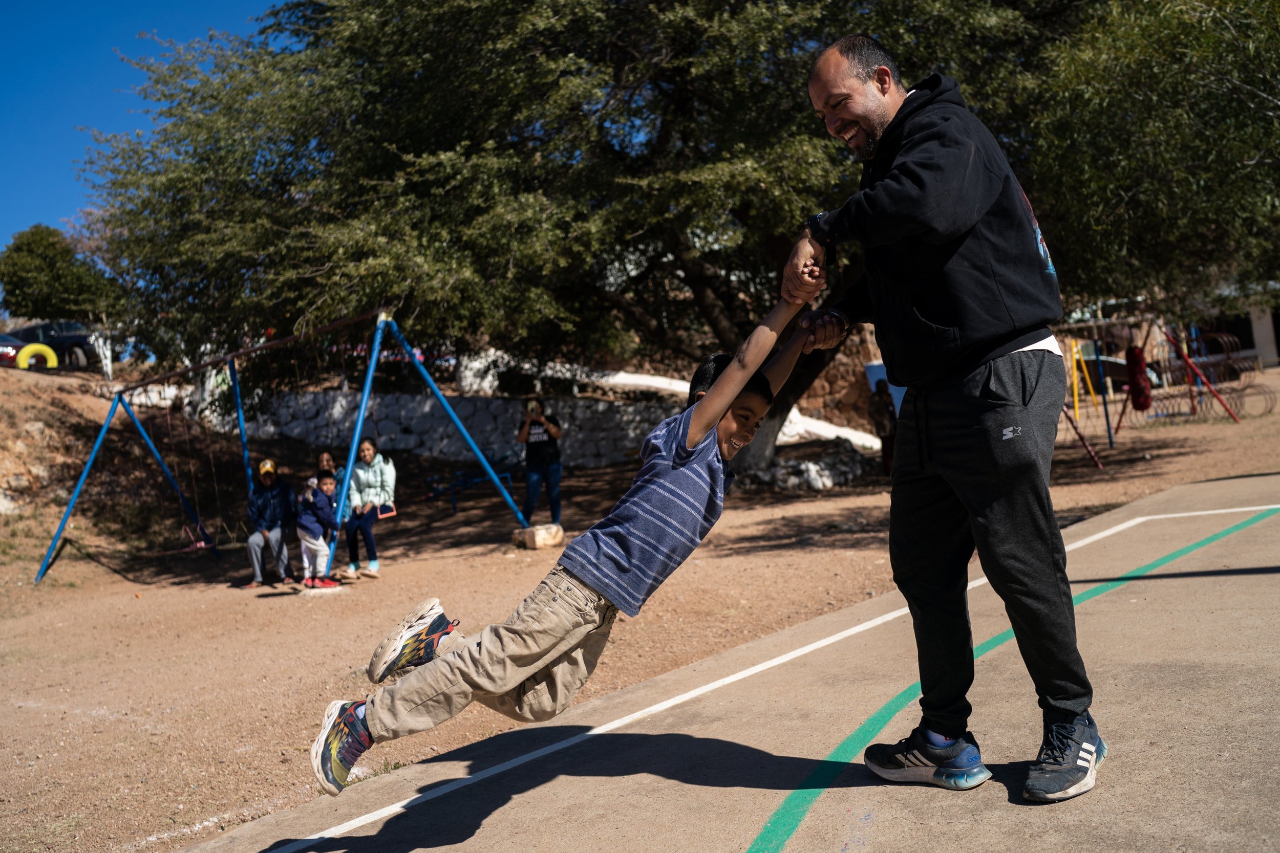  Jesse Urquidez, at right, spins a migrant child, who’s name has been omitted for safety concerns, during a recess between classes at La Casa de Misericordia on Friday, Jan. 7, 2023, in Nogales, Mexico. 