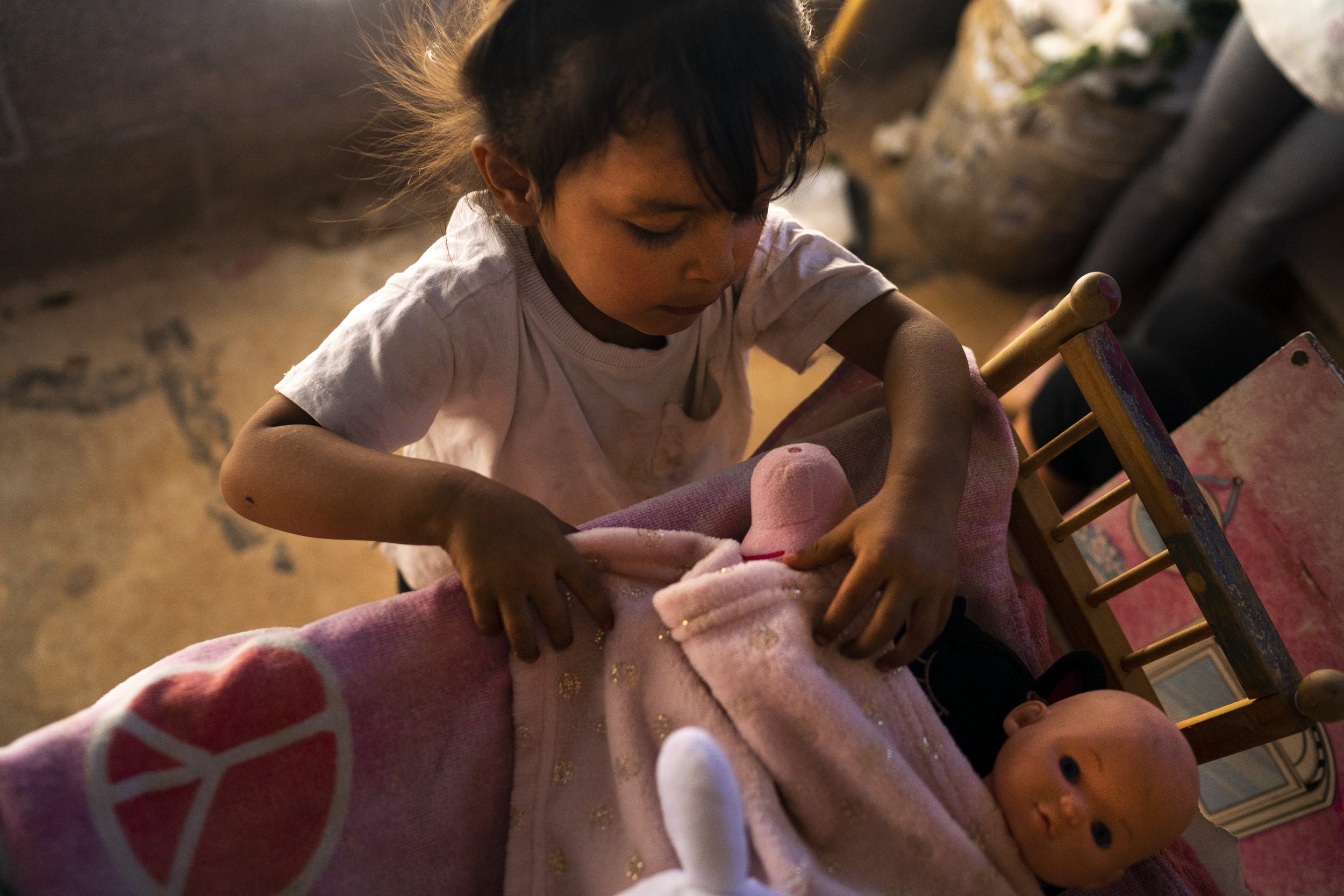  Amaya Delgado García, 2, tucks her baby doll into a crib at her home on the outskirts of Nogales on Monday, May 23, 2022, in Nogales, Mexico. Her family moved to Nogales to apply for asylum after her father was kidnaped by the cartel for four days. 