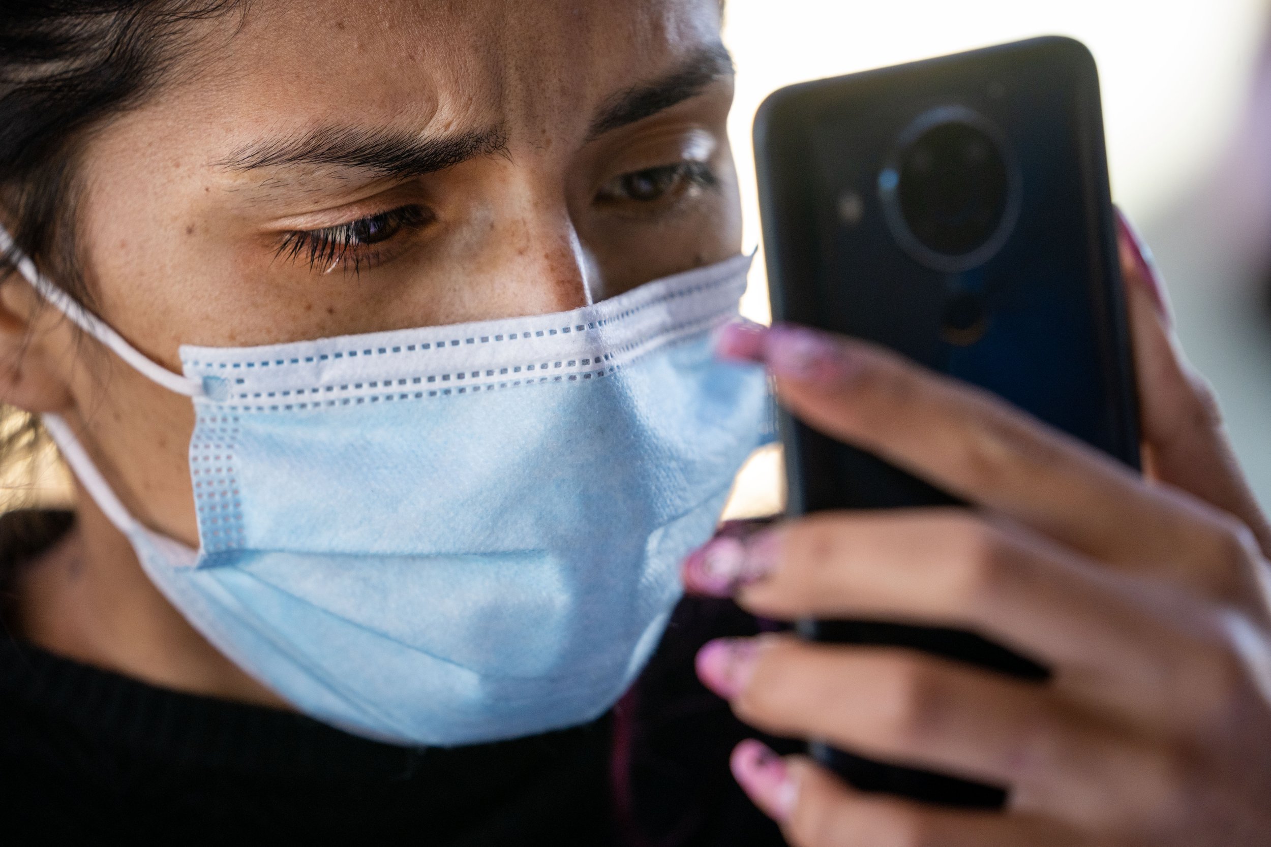  Karol Buitrago cries as she talks to her sister-in-law in Miami to update her on their travel schedule and safety while at Iglesia Cristiana El Buen Pastor on Thursday, Dec. 22, 2022, in Mesa. Buitrago, a nail stylist from Colombia, fled her home af