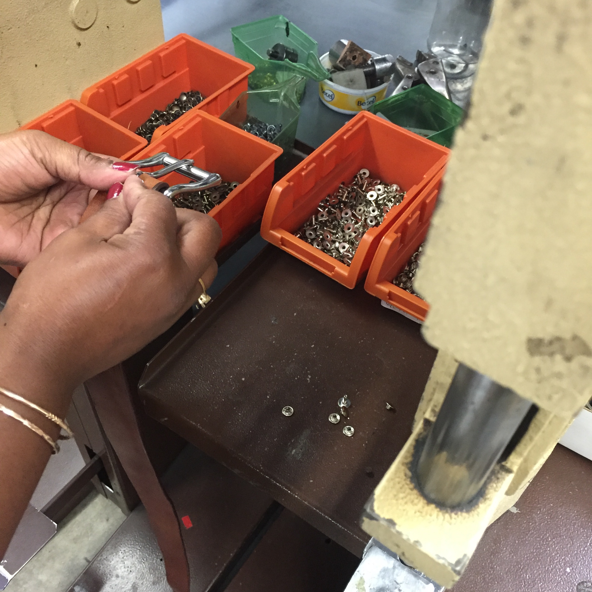 9. The buckle and self leather stay are riveted in place. This lady prepped it for me and then I did this on the machine you see on the right.