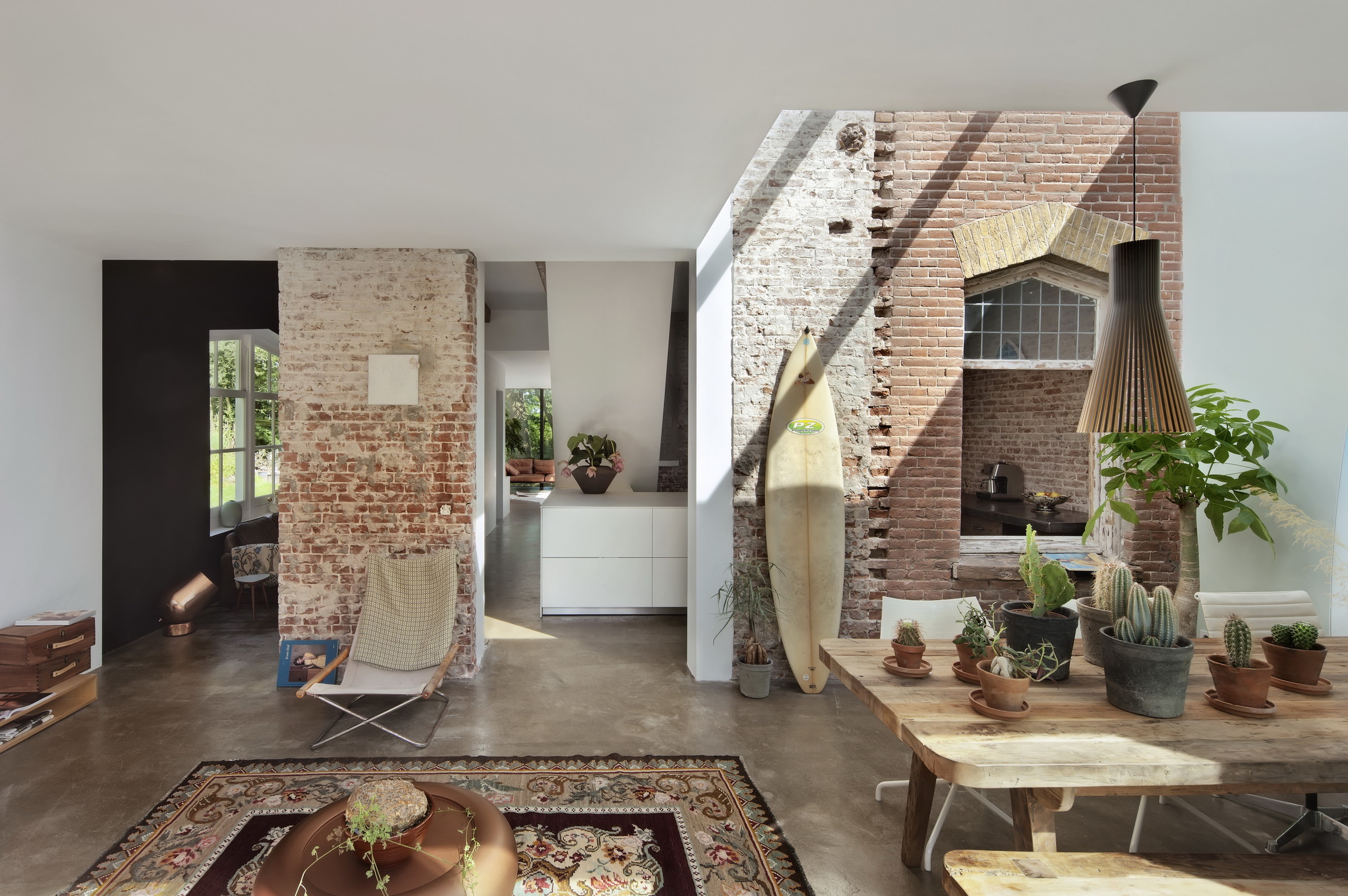  An old railway cottage in Santpoort, The Netherlands by  Zecc Architecture  is flooded with light and maintains its industrial edge. A sunbleached board basks in some rays. 