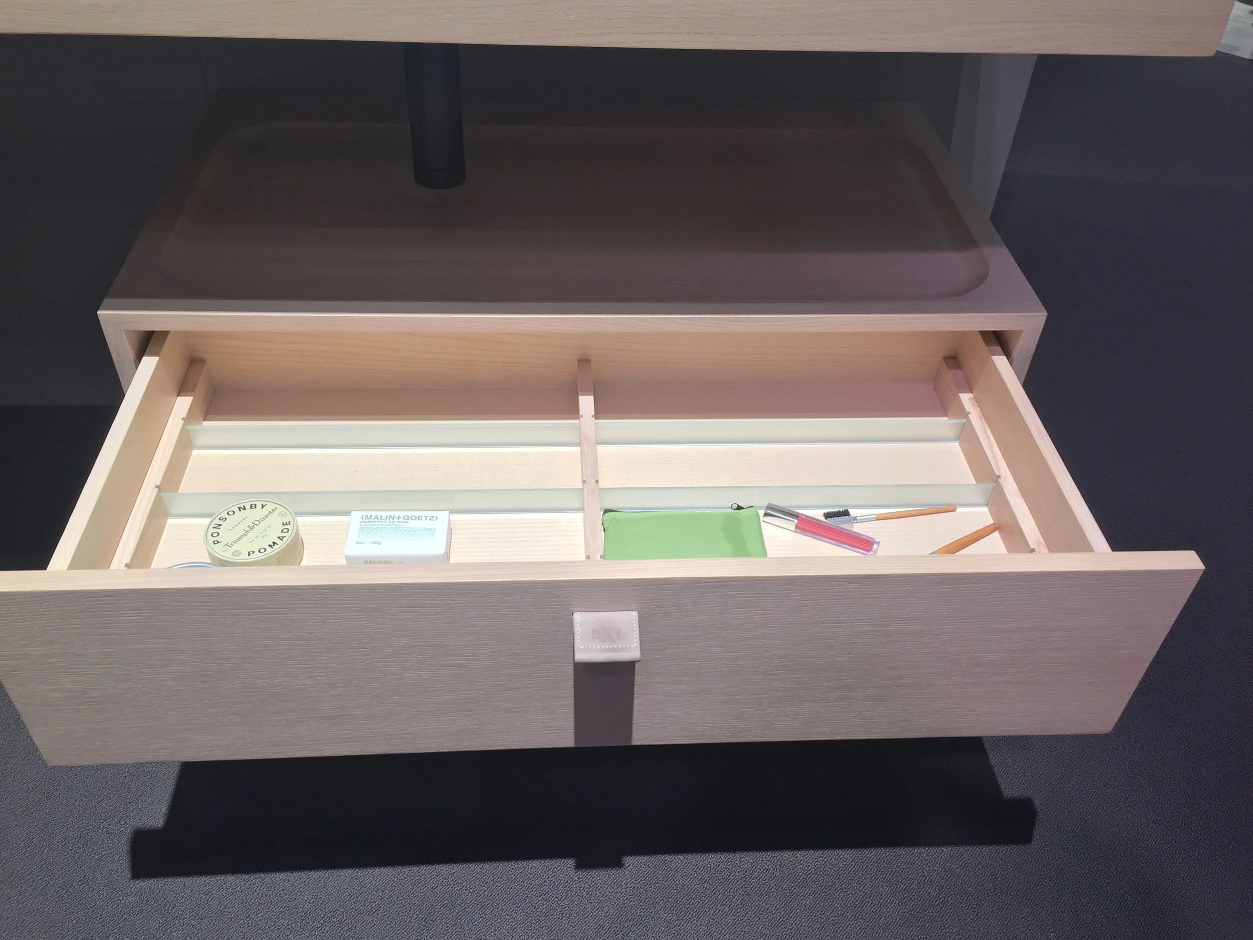 When not in use, the tray from the sink can nestle right on top of the wall-mounted drawer, which is kitted out with clever storage compartments.