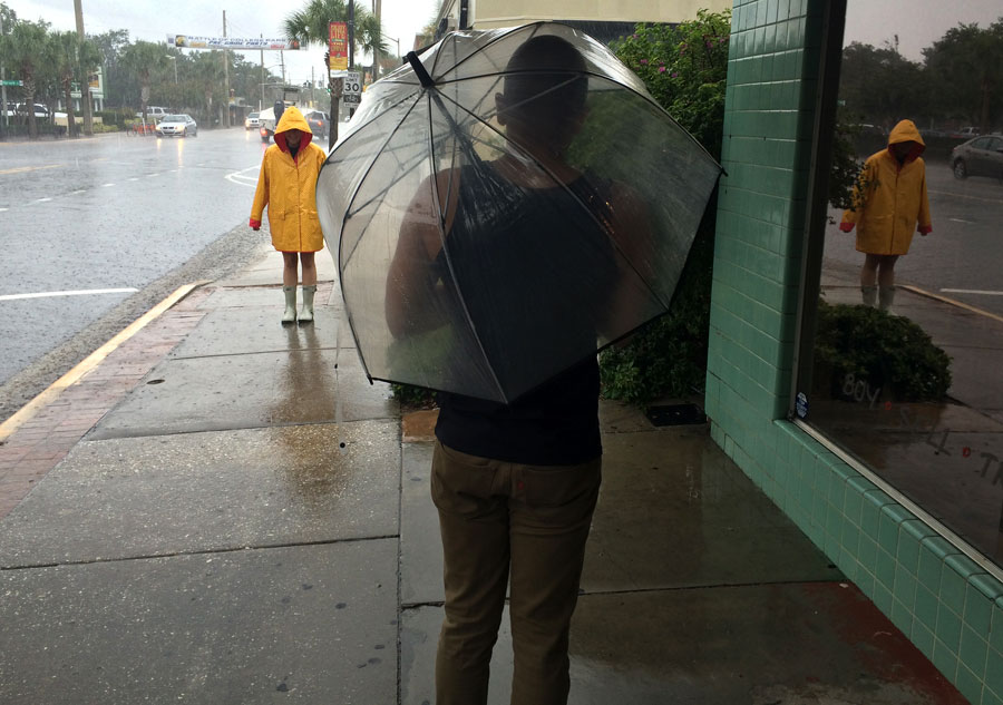 When it rains, it pours. Tierney Lister is geared up and ready for the rain. Mikey Massas prepares to brave the downpour. 