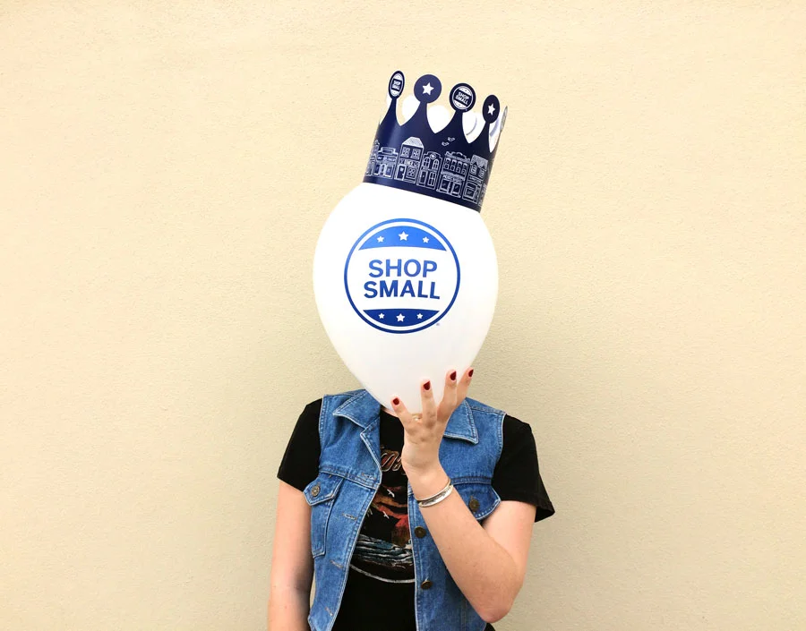 🎈 Shop small and feel like royalty - especially today. 🎈 (That's Caralyn, our newest team member behind the balloon. We welcome her, she welcomes you.).