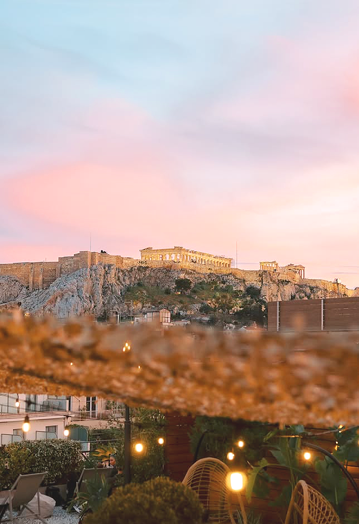 As evening settles across Athens and the Parthenon begins to glow