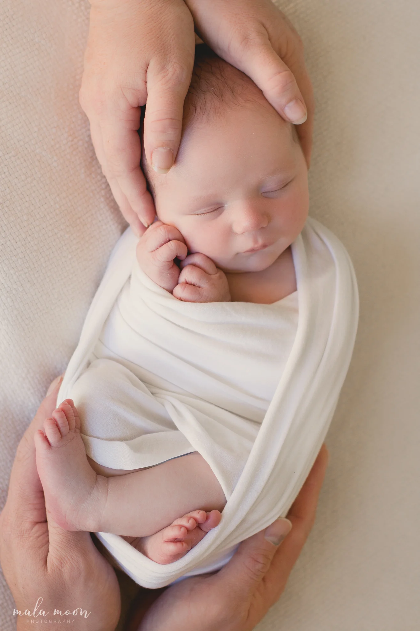 newborn-with-mum-and-dads-hands