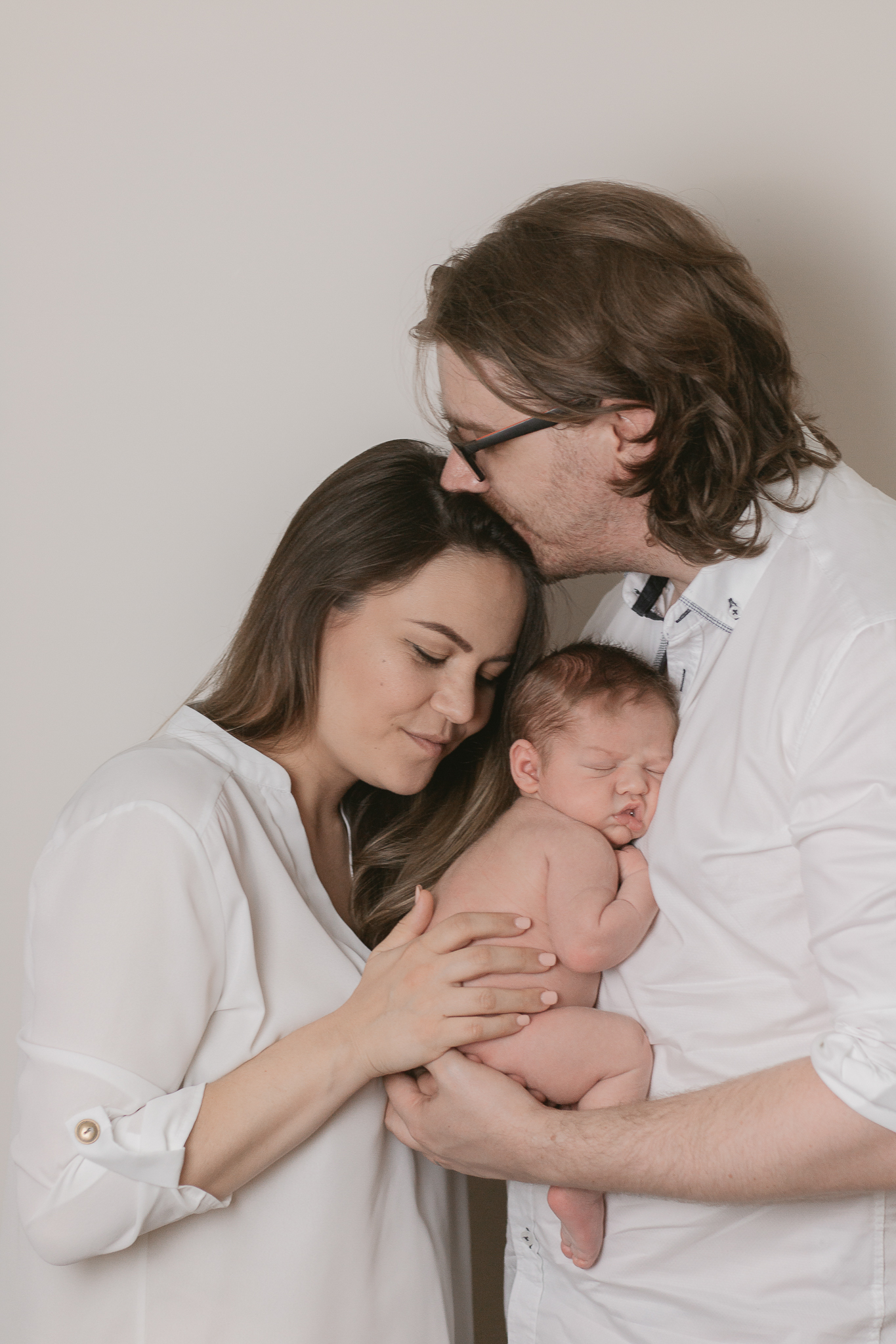 family of three holding their new child