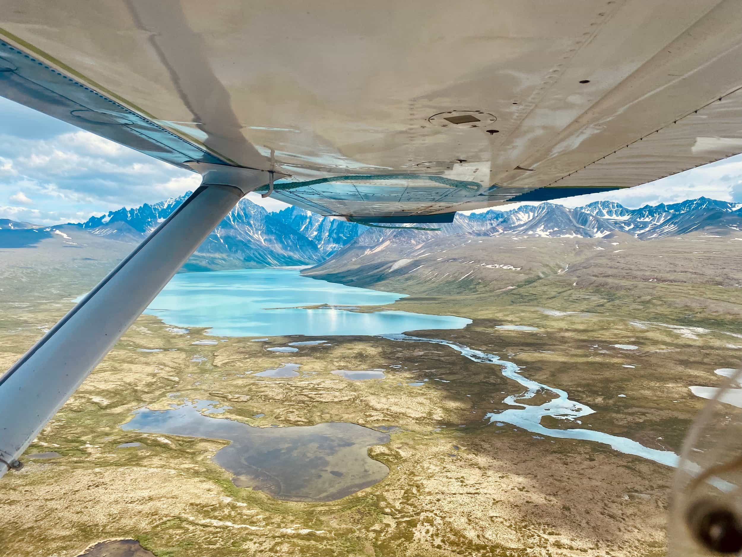 Looking out over a bright blue lake from bush plane.