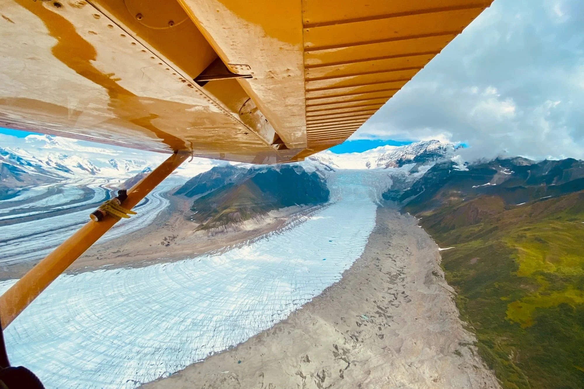 Looking out bush plane at curving glacier below.