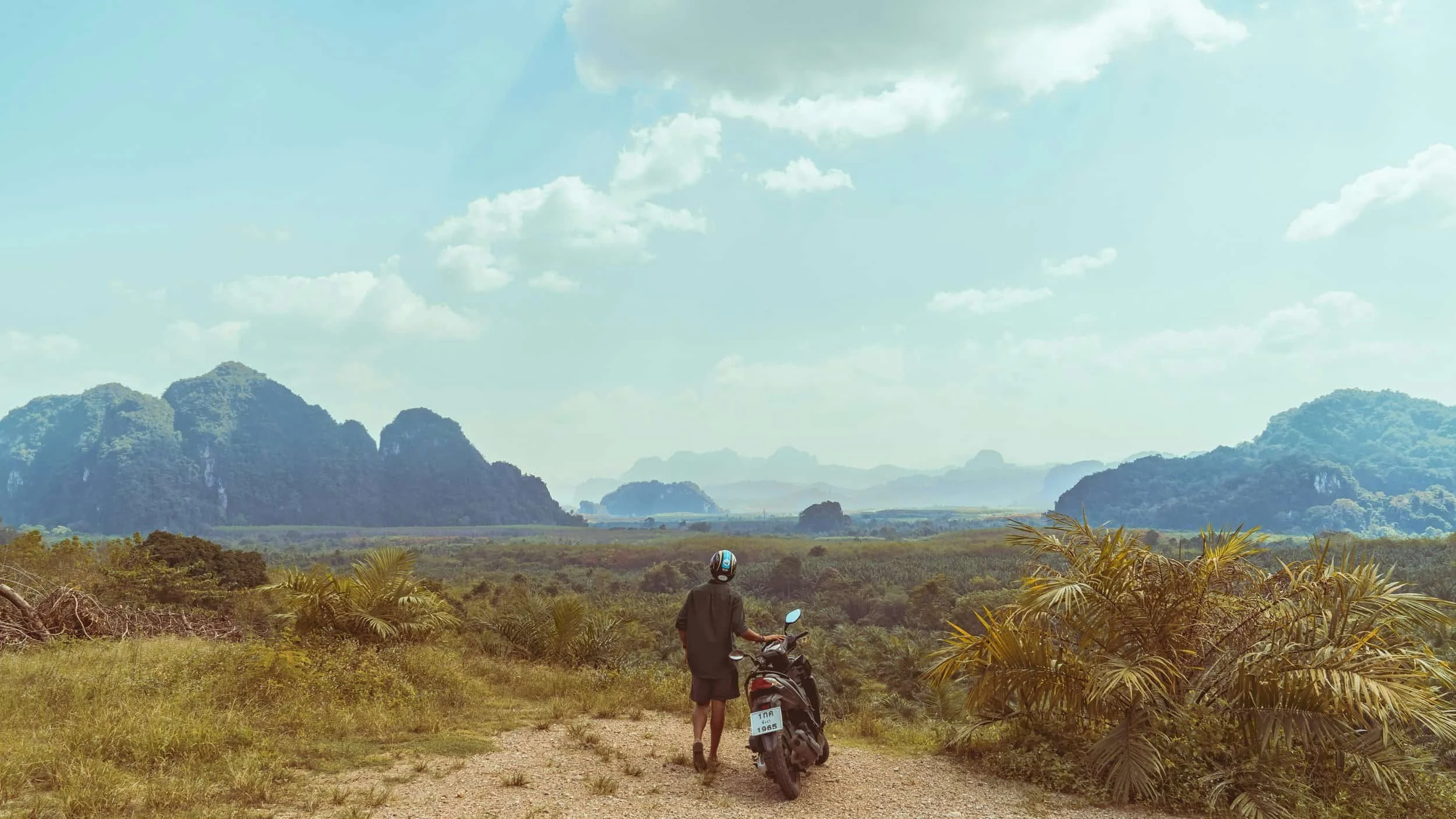 Person with scooter looking out over islands.