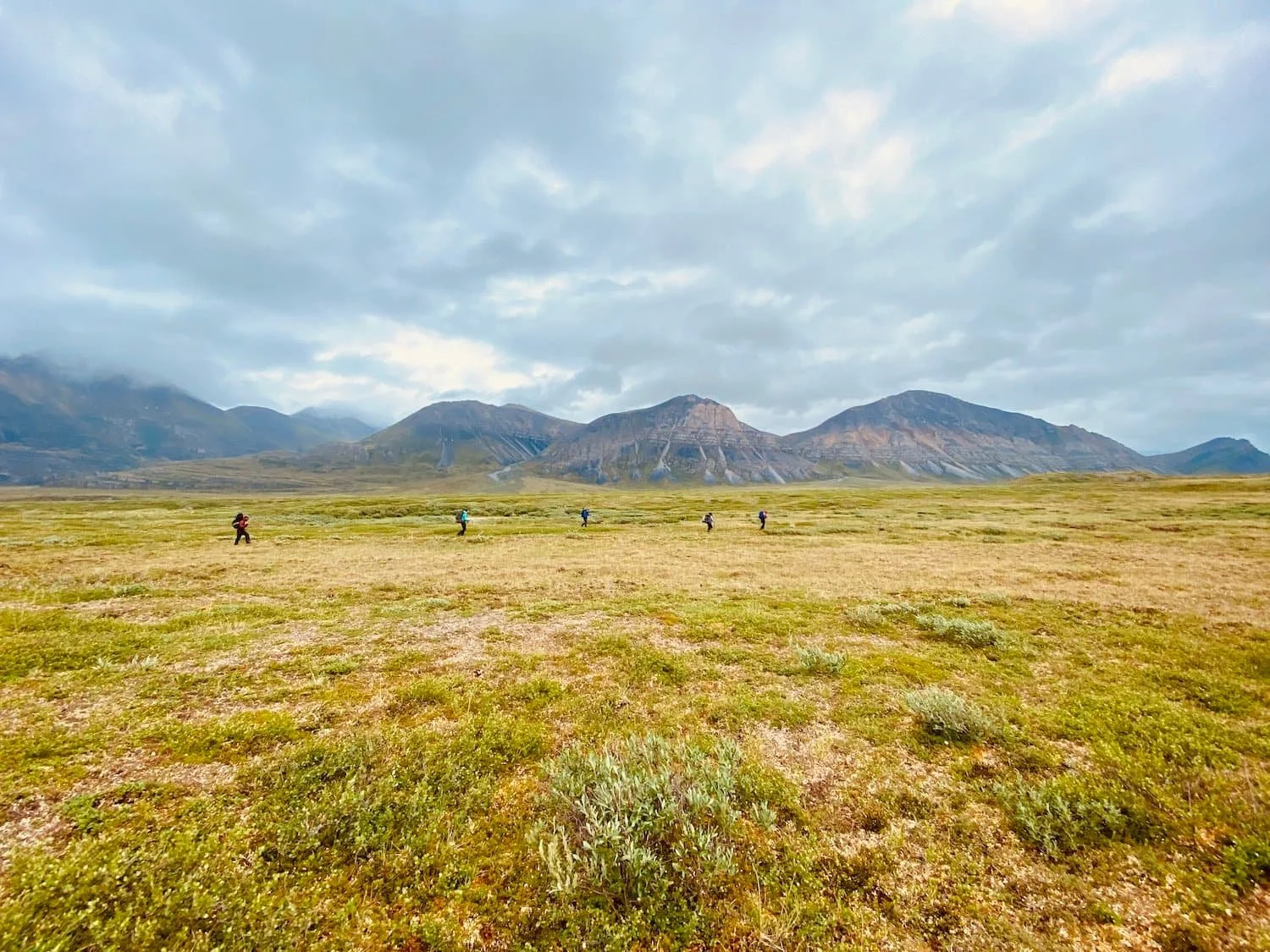 Backpackers hiking through valley in Alaska.