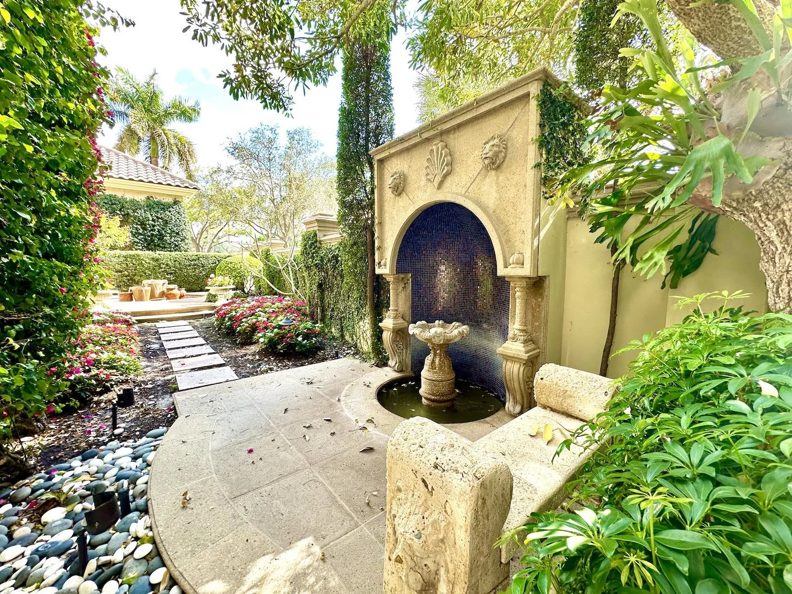Mediterranean fountain in tile niche with pathway and seating