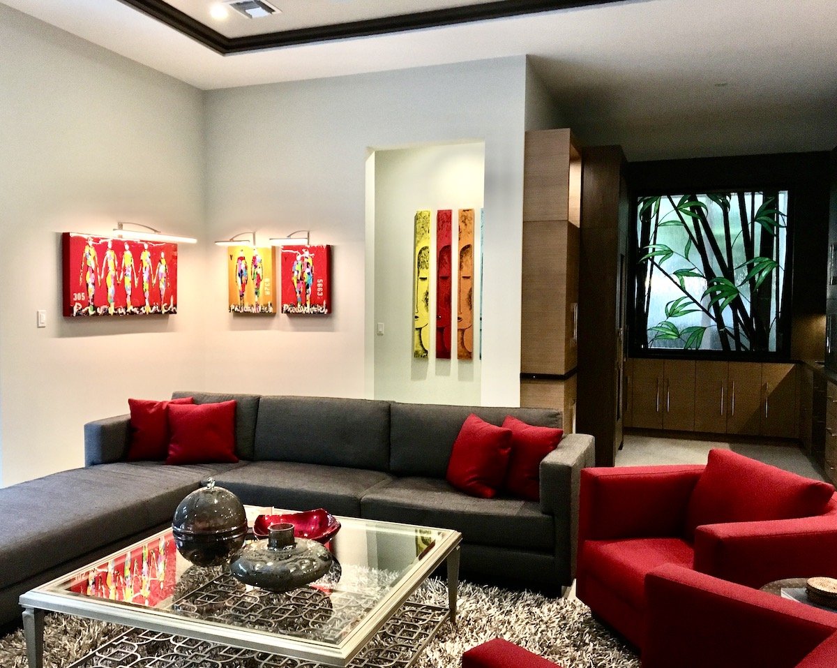 modern family room with custom brown sofa and two red chairs including modern red and yellow artwork in Fort Lauderdale beach