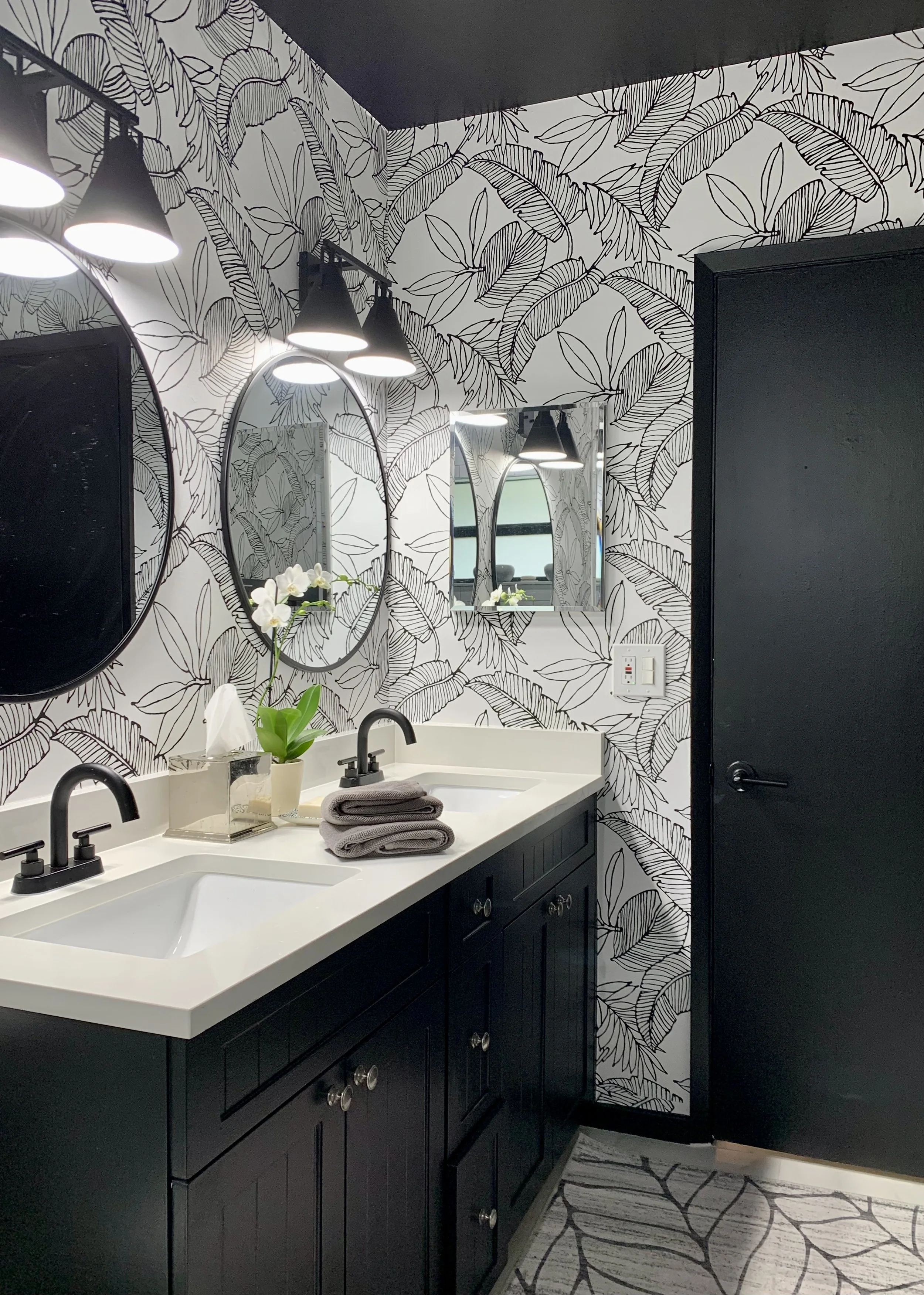 modern bathroom with tropical black and white wallpaper with black cabinet and architectural moldings in Fort Lauderdale