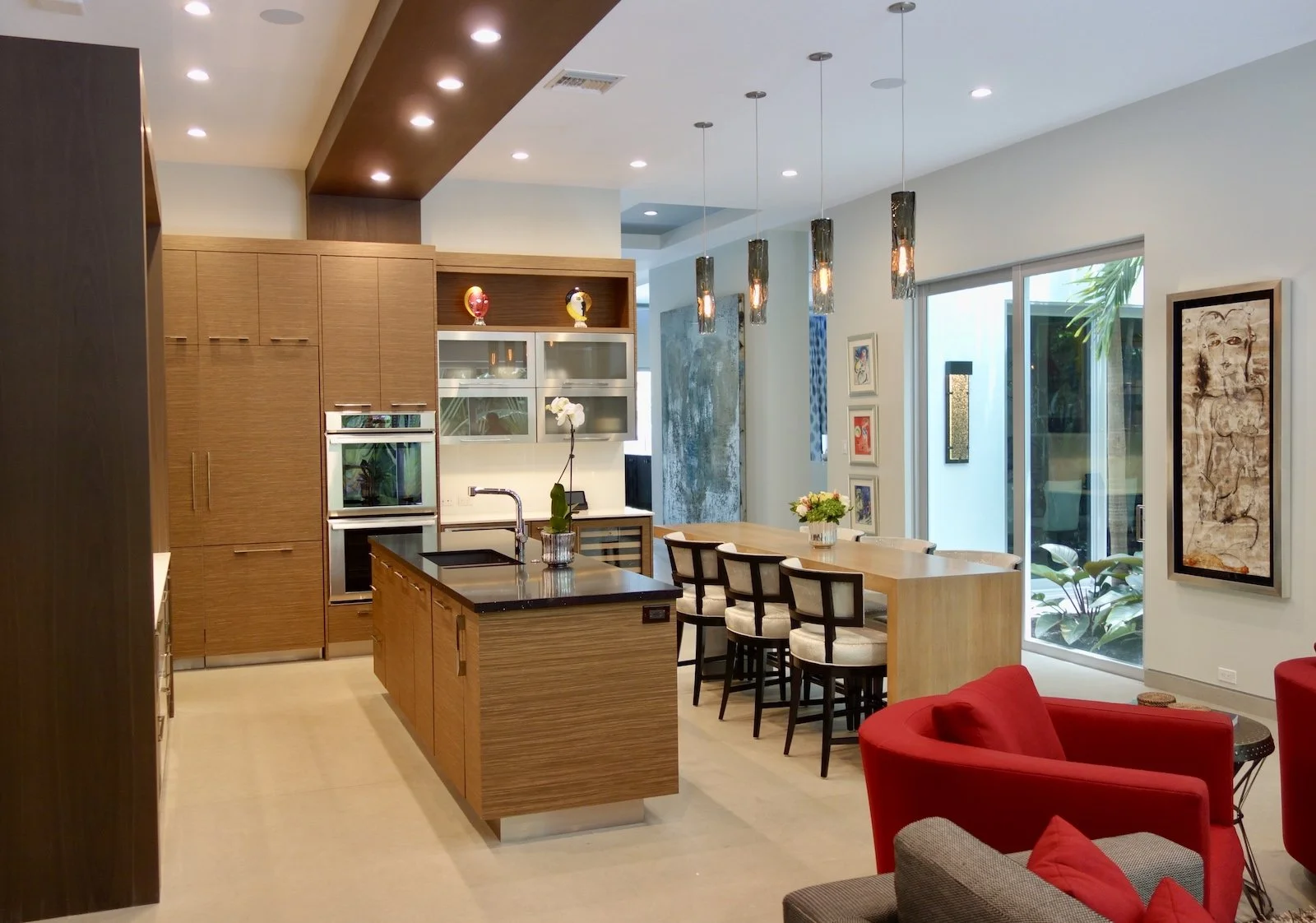 modern custom kitchen with island for seating and island for sink with architectural bridge over range and island in Fort Lsuaderdale