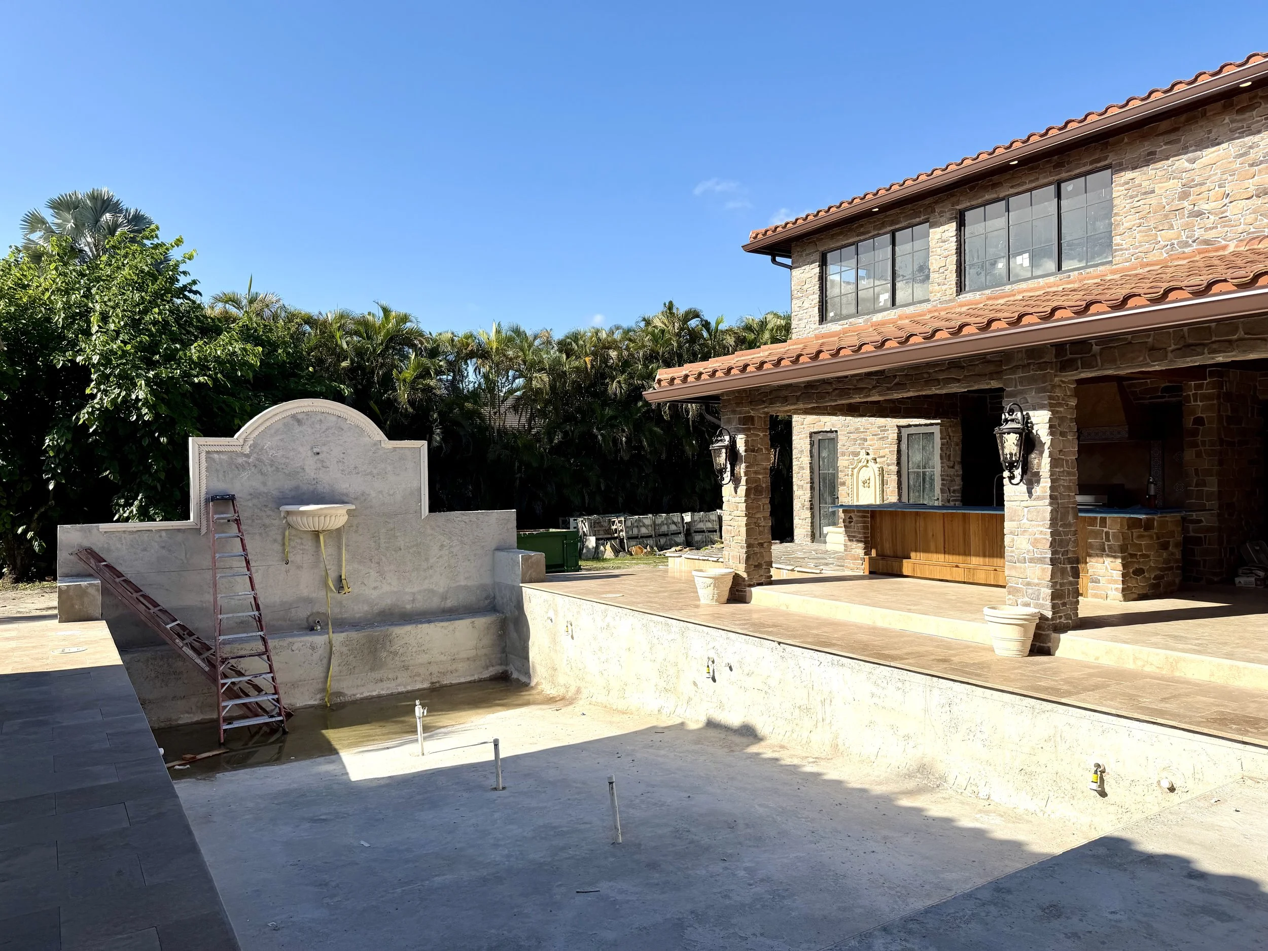 Mediterranean design-build pool in Boca Raton with arched fountain wall and courtyard layout