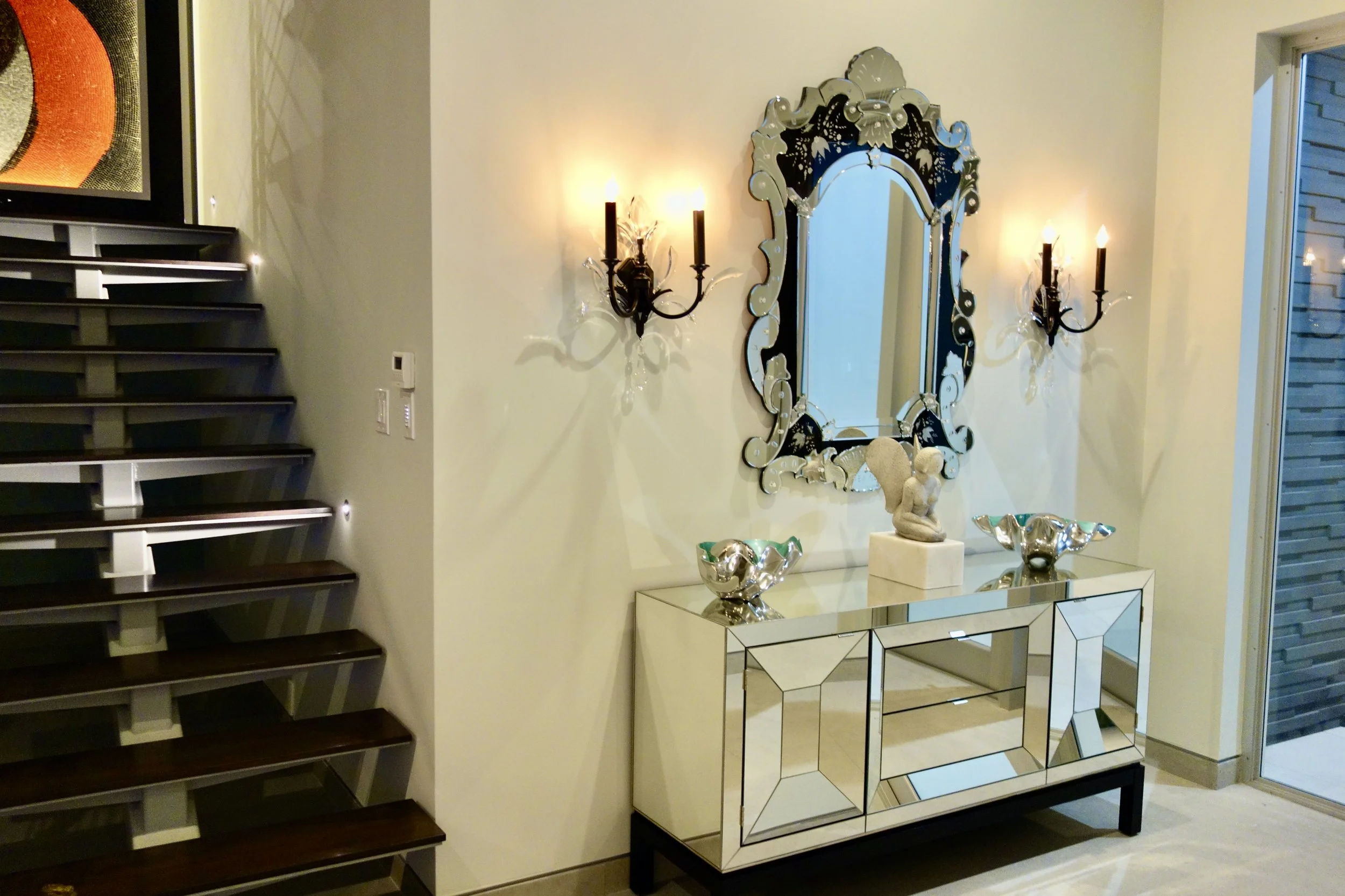 modern foyer with traditional Venetian mirror over a mirror table with modern crystal sconces