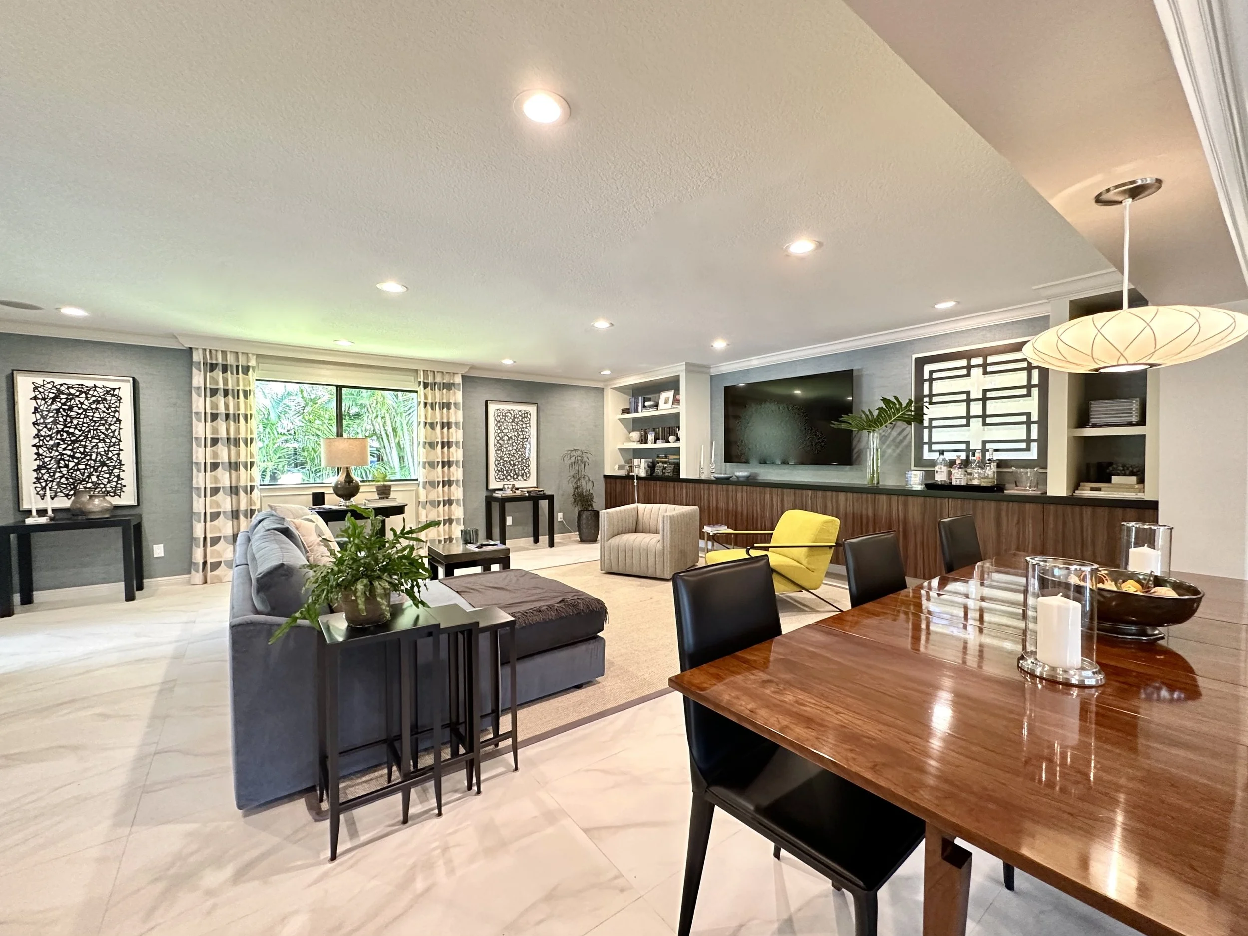 Modern dining area is looking into family room with Mid Century wall unit in Fort Lauderdale
