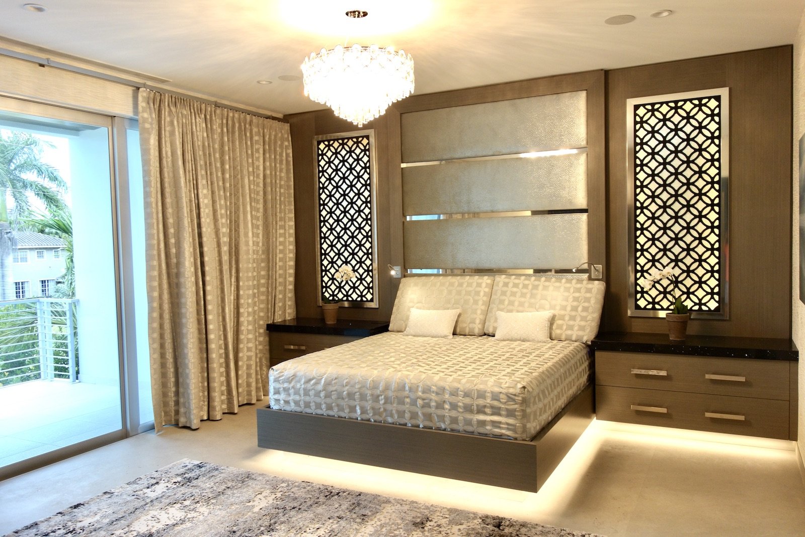 Modern primary bedroom with custom built in bed, nightstands, headboard, and panels over the windows in Las Olas