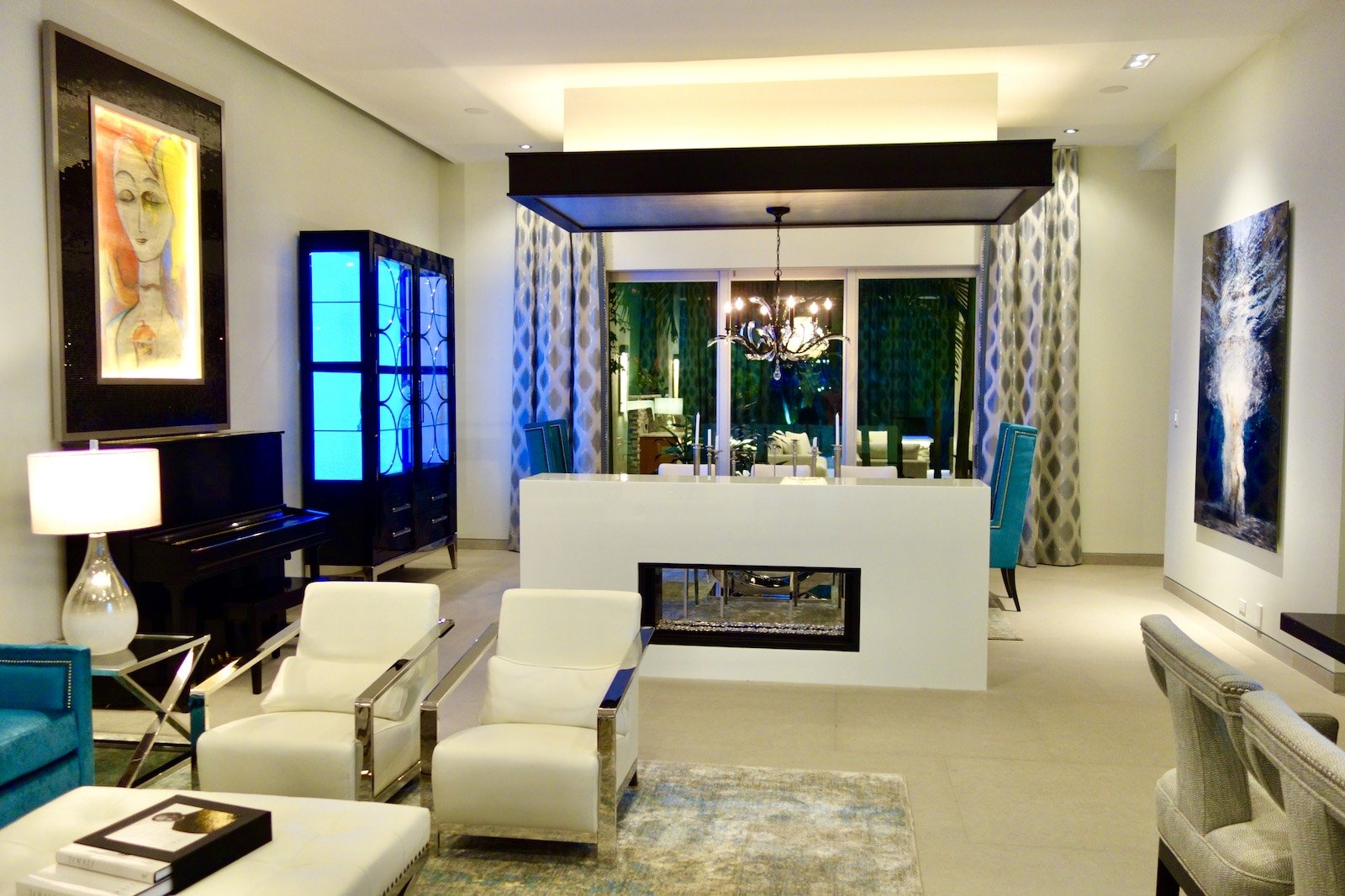 Modern great room and dining area with fire place, piano, and custom funiture