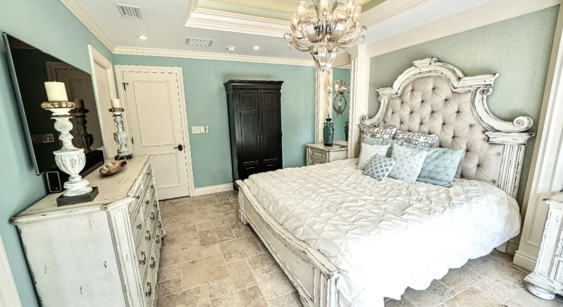Traditional coastal bedroom with columns and tray ceiling in Fort Lauderdale