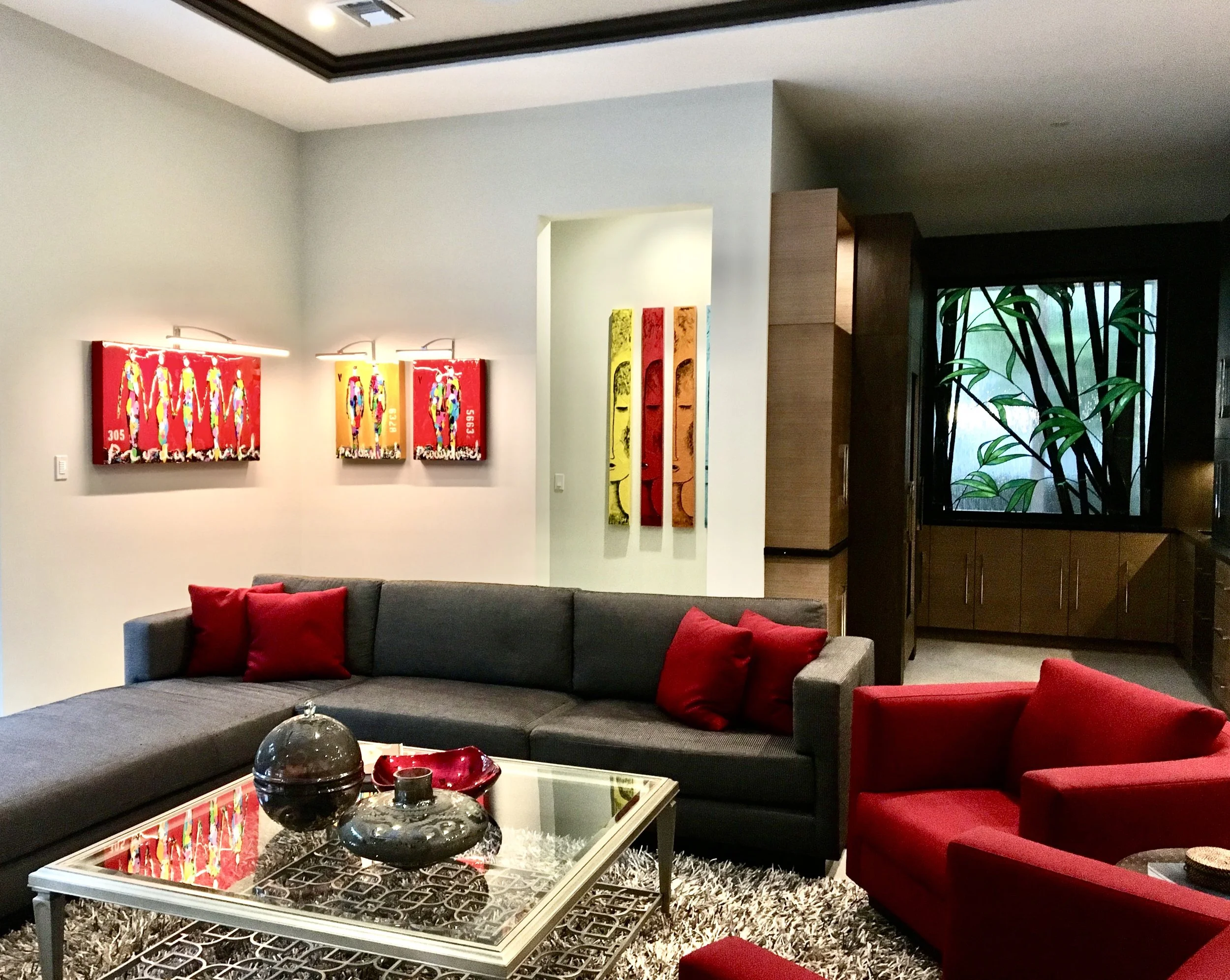 modern family room with custom brown sofa and two red chairs including modern red and yellow artwork in Fort Lauderdale beach