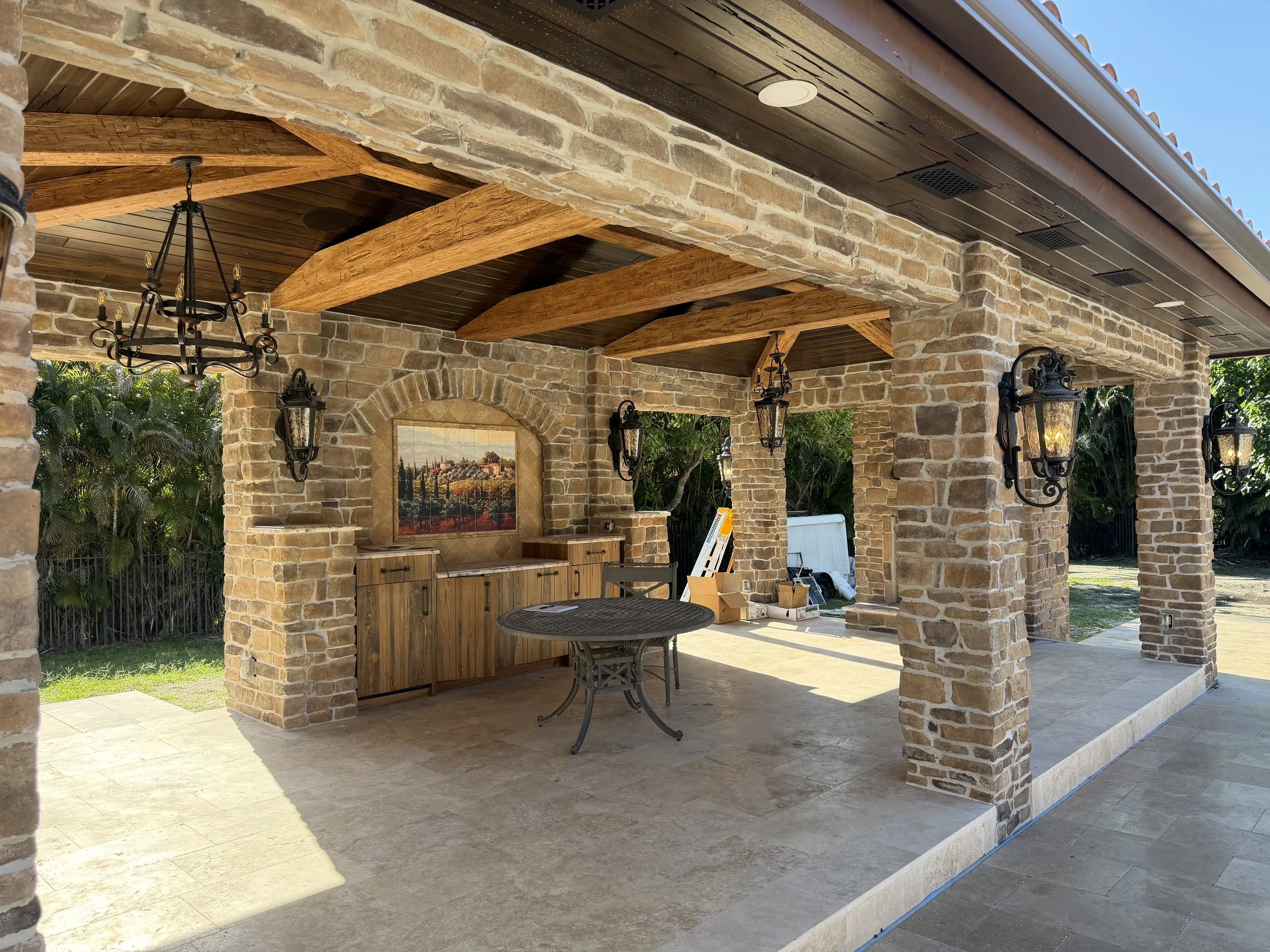 Mediterranean design-build home in Boca Raton with stone exterior and covered outdoor gazebo