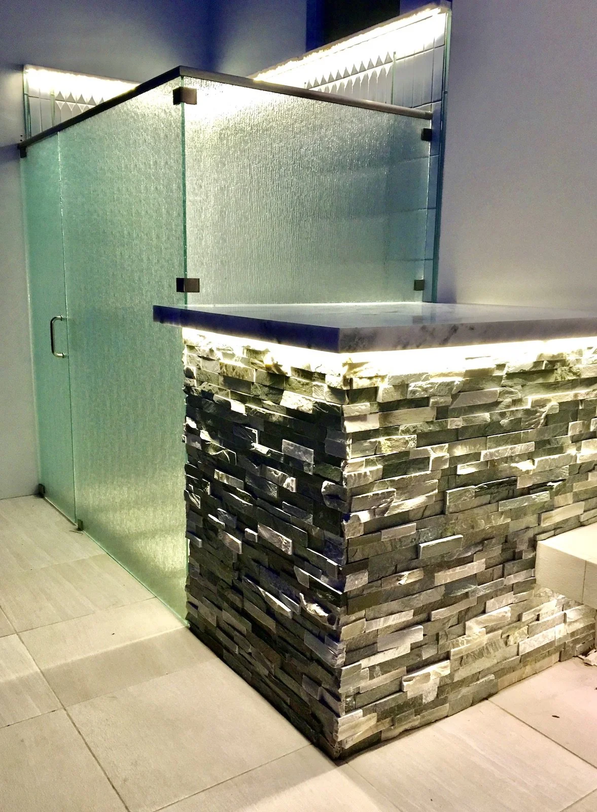 luxury outdoor tile shower with LED lighting and stone column