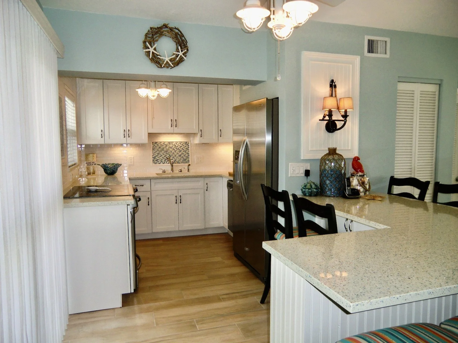 modern coastal kitchen with white custom cabinets, beadboard, subway tile backsplash