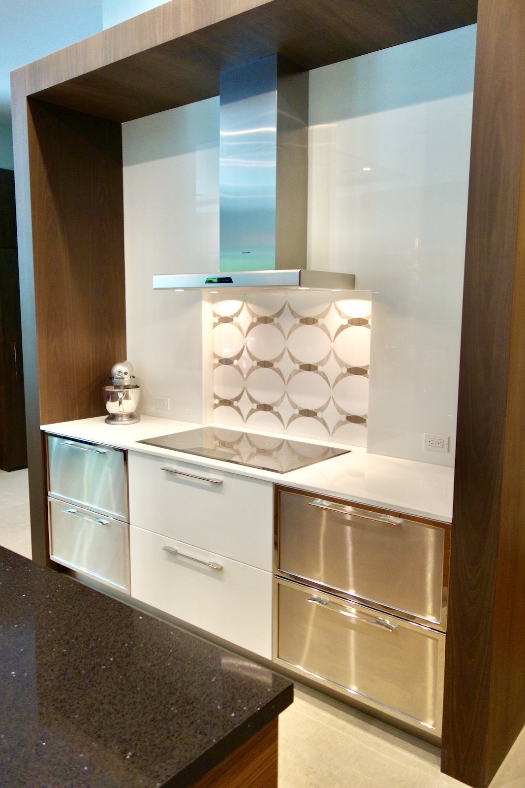 luxury modern kitchen in Fort Lauderdale with custom cabinets with wood bridge over the cook top