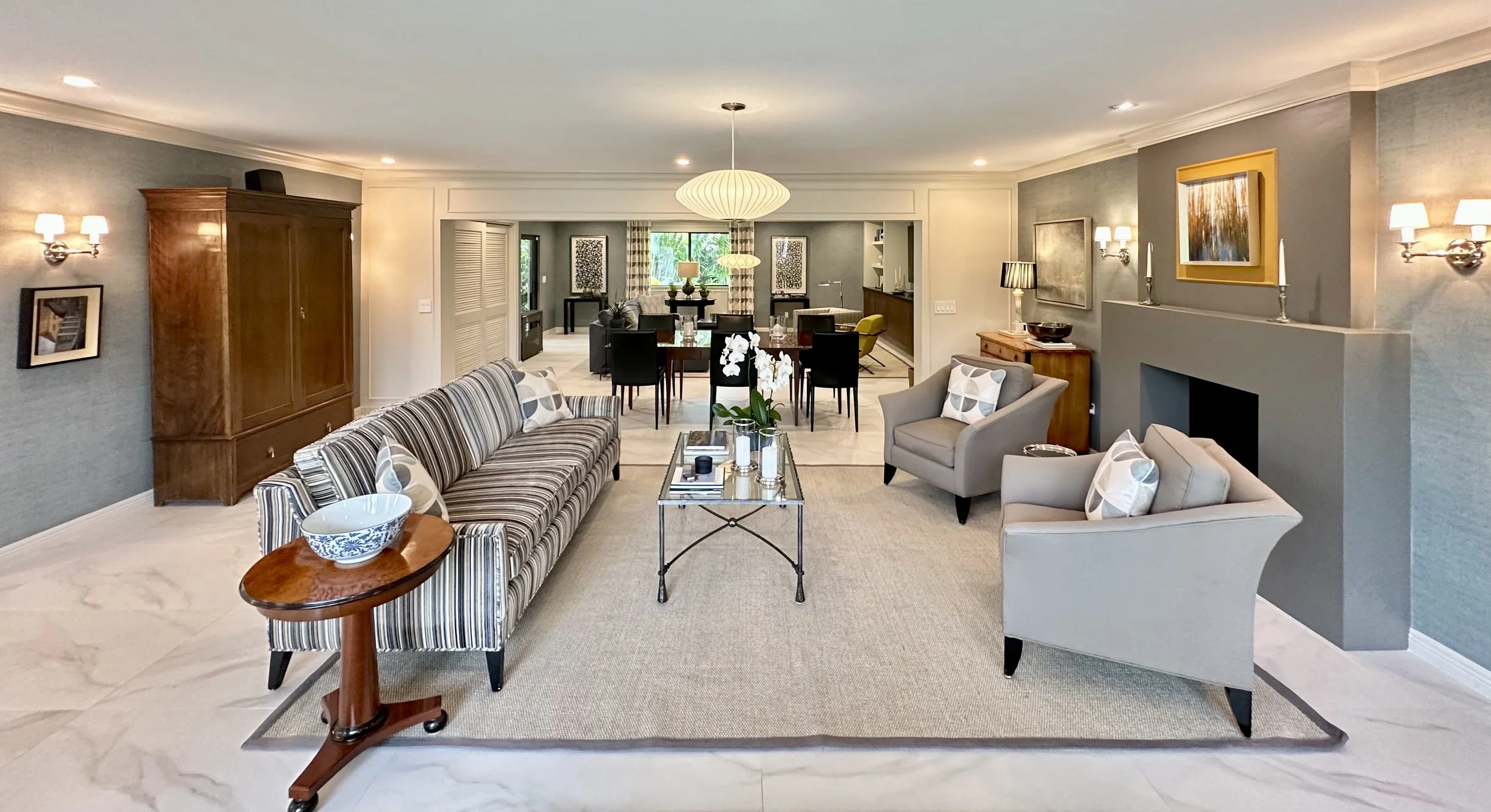 modern living room with traditional moldings and armoire with flanking sconces in Fort Lauderdale