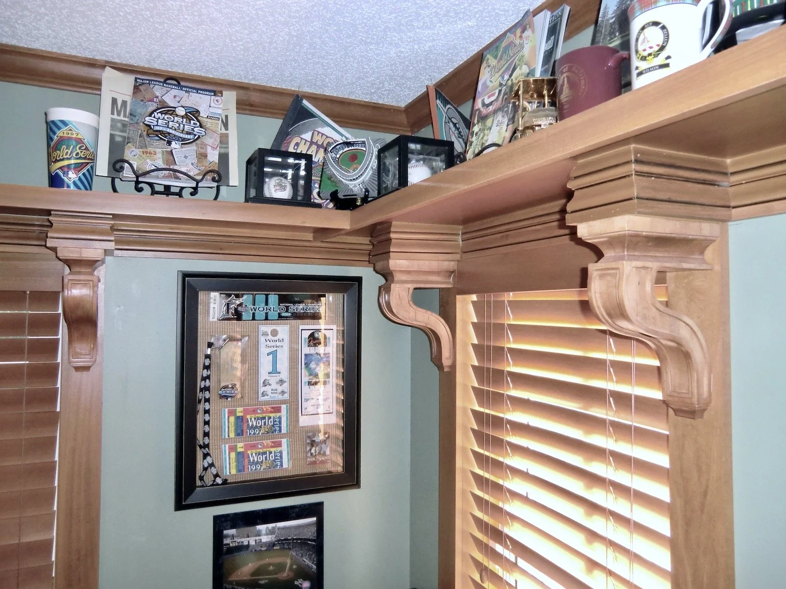 transitional home office with custom shelves and traditional corbels to hold sports memorabiliabilia
