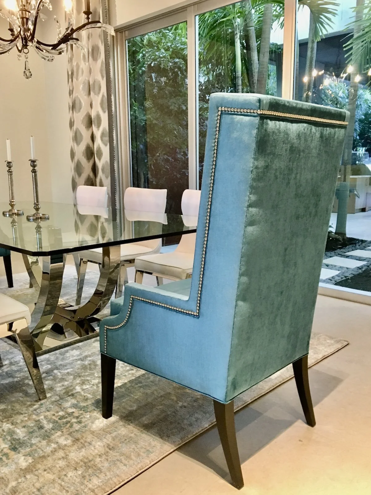 modern dining room with custom blue velvet chairs and chrome and glass top table in Fort Lauderdale