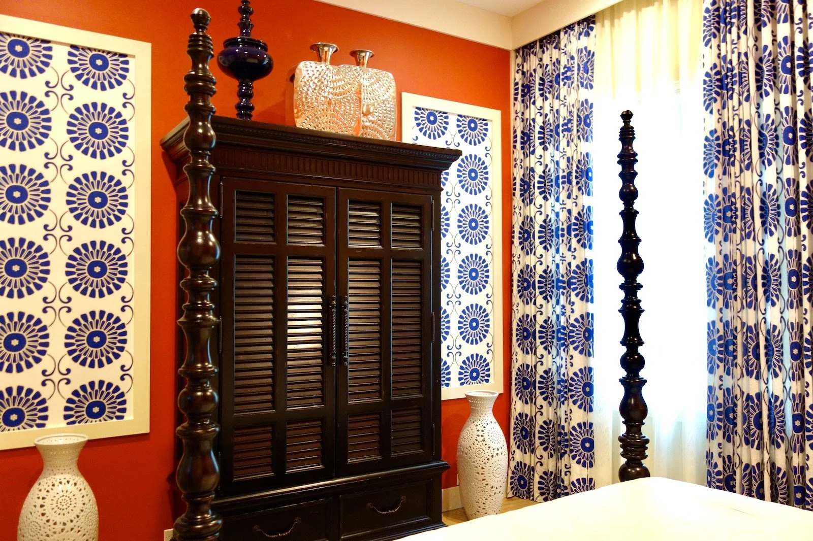 red bedroom with dark colonial four poster bed with Batik fabric and armoire in Fort Lauderdale