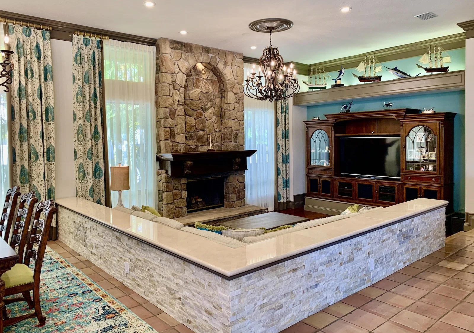 luxury modern Mediterranean family room with fireplace and dining area with wrought iron chandeliers in Boca Raton